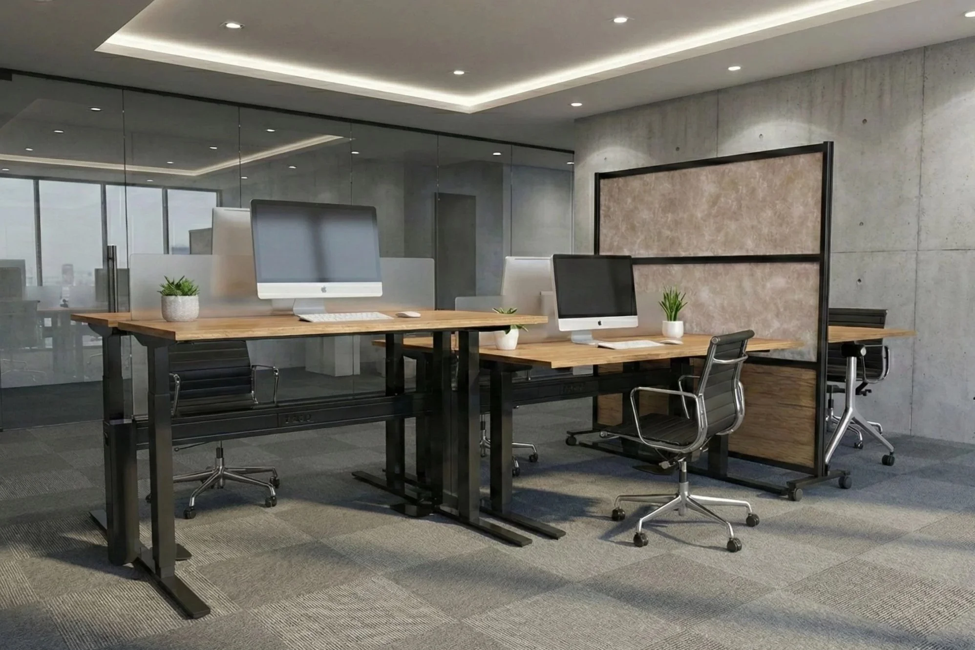 Modern office workspace with wooden desks, black ergonomic chairs, desktop computers, potted plants, and a large mirror on the wall in a well-lit room with ceiling lighting.