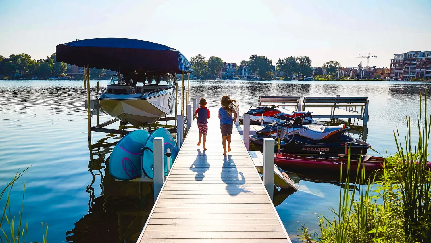 Luxury Wisconsin waterfront featuring a Lifetime pier system at sunset.
