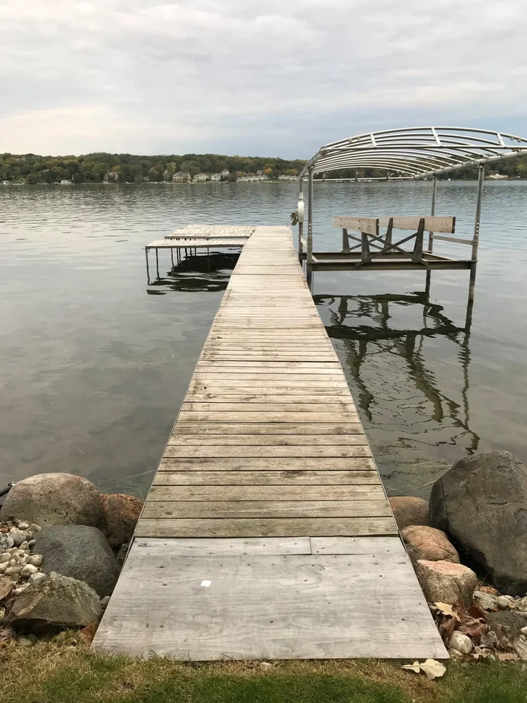 Older wooden pier and boat lift setup on a Wisconsin lakefront property showing an aging waterfront layout.
