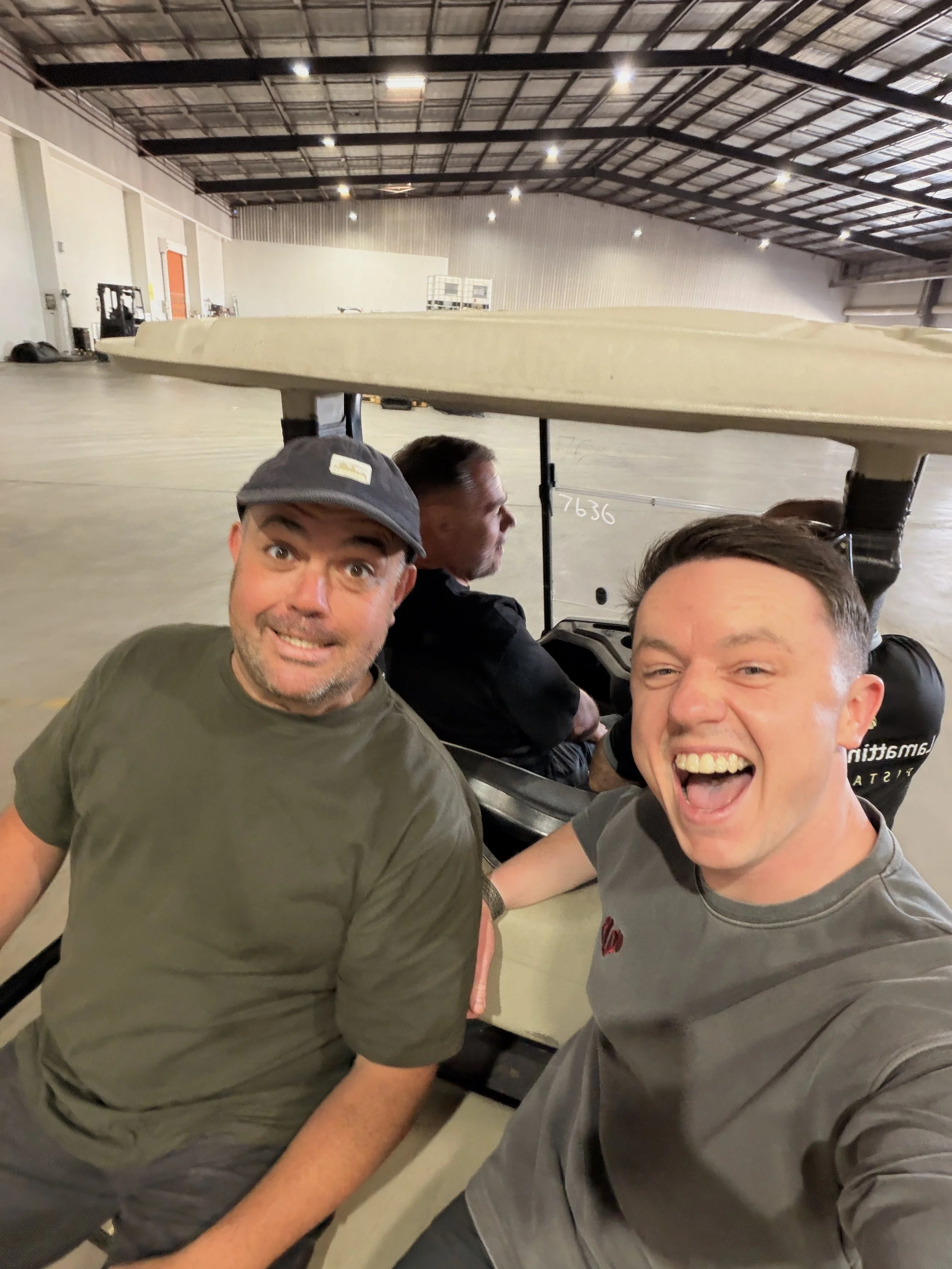 Brad in Golf cart, warehouse, mid-laugh