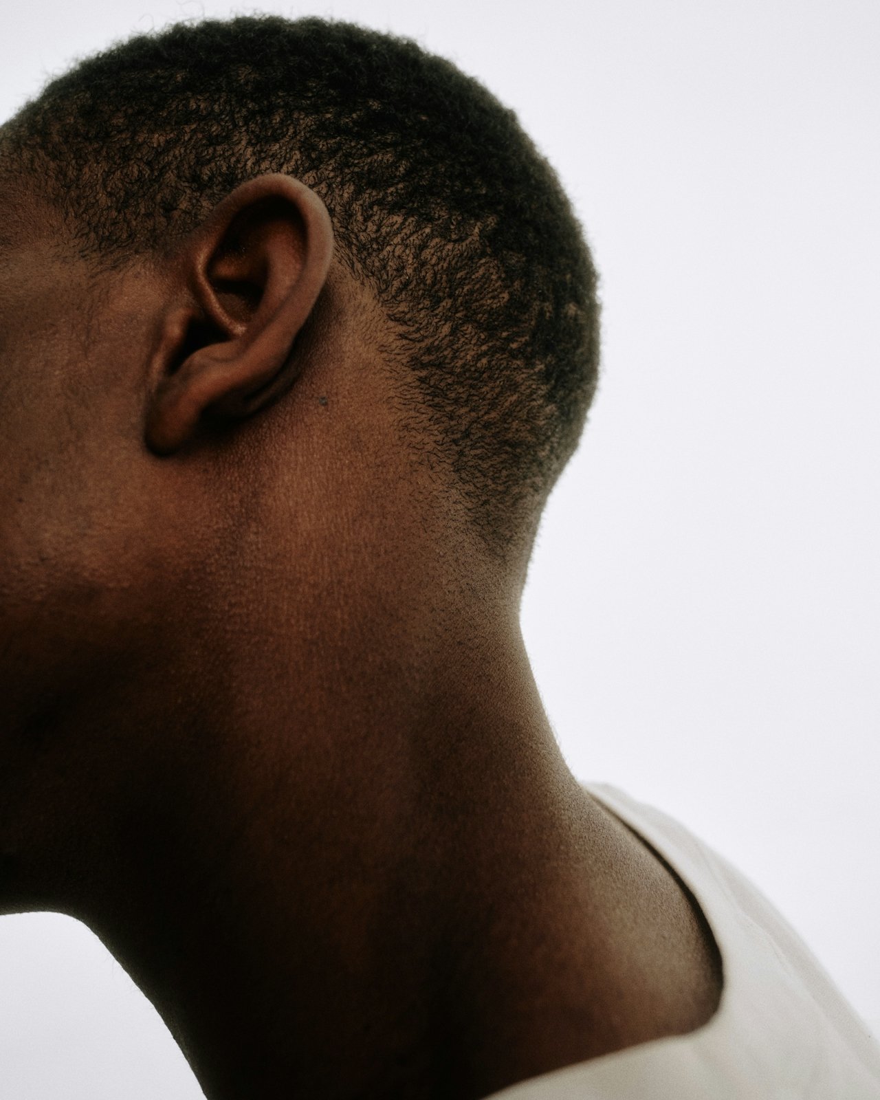 Woman with vibrant red hair styled by a JCI hair art design student during a practical session.