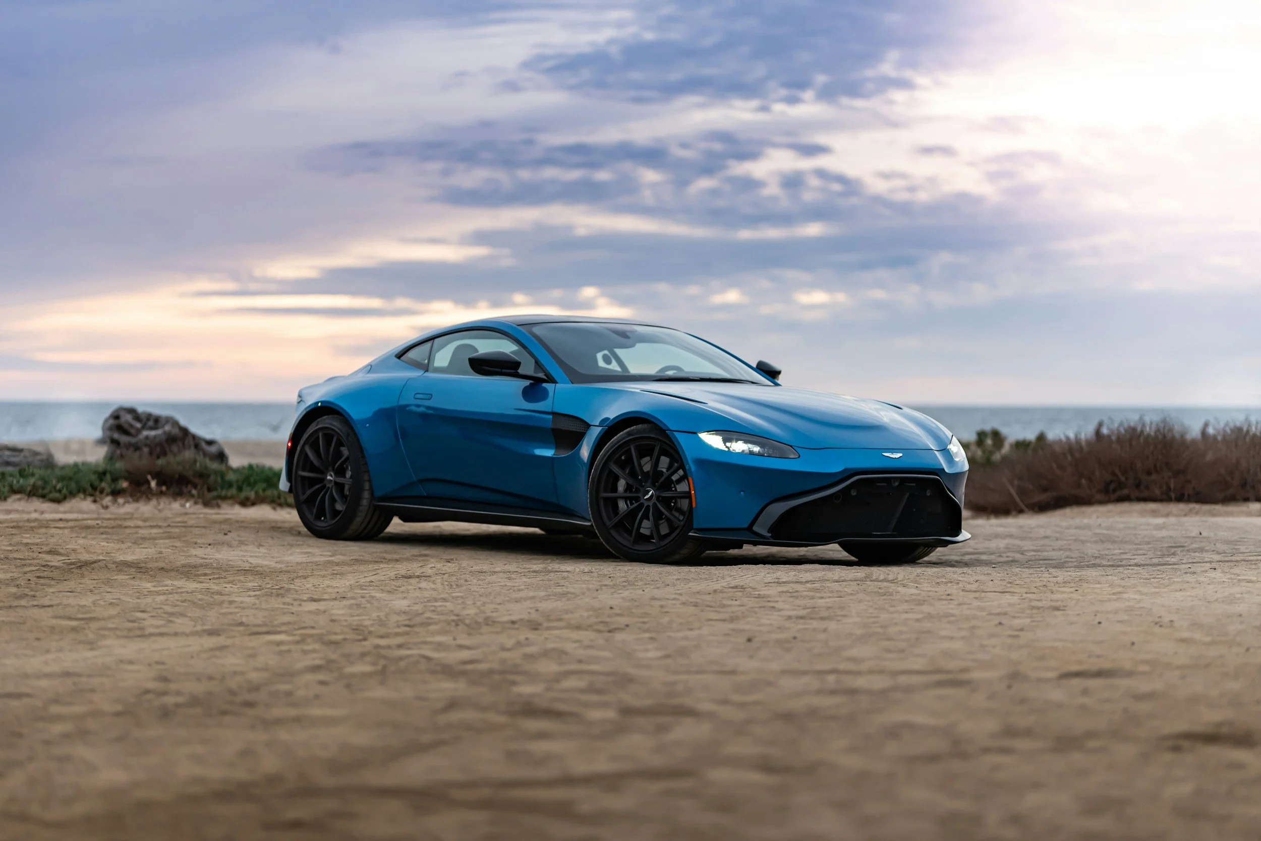 alt="Blue Porsche 911 sports car parked on sandy road under white clouds – featured in a professional mobile car detailing demo by Alex’s Mobile Car Detailing in Everett, Washington."