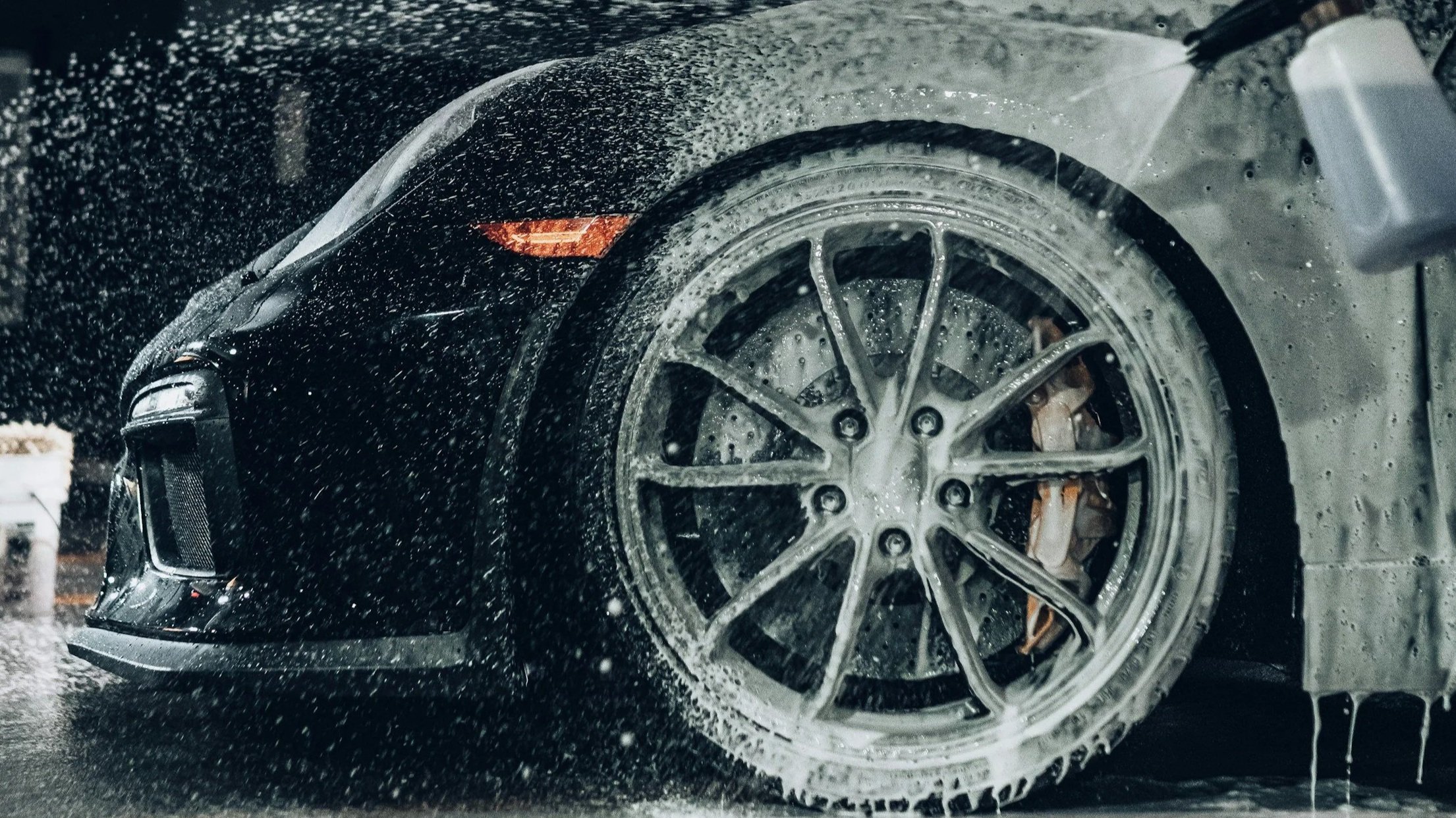 Close-up of a car wheel being cleaned during a professional mobile car detailing service