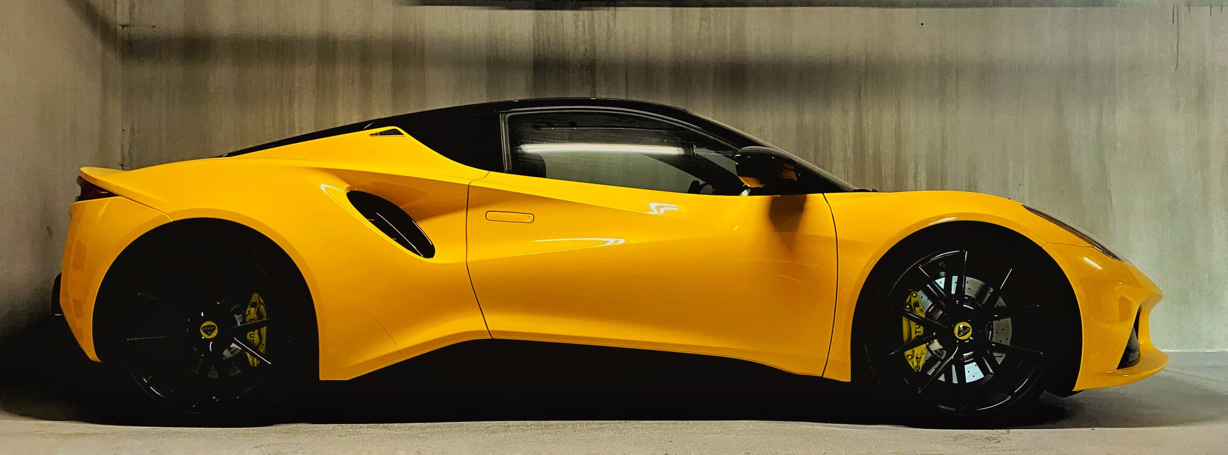 alt="Sleek yellow sports car parked in a building parking lot after a professional mobile car detailing service by Alex’s Mobile Car Detailing in Everett, Washington."