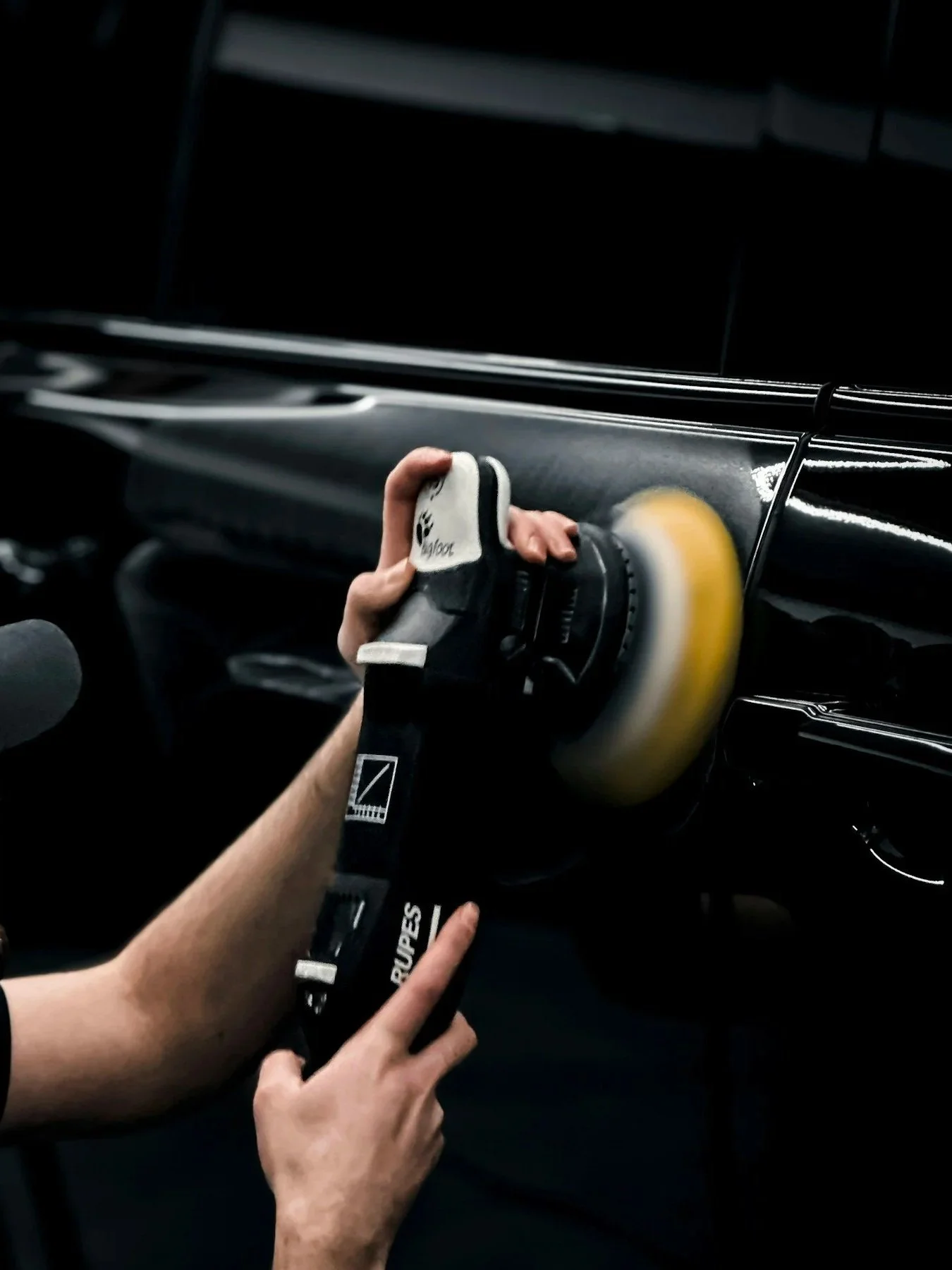 Close‑up of a professional technician applying special wax to a vehicle body during a mobile car detailing appointment—bringing scratch removal and showroom shine right at your doorstep.