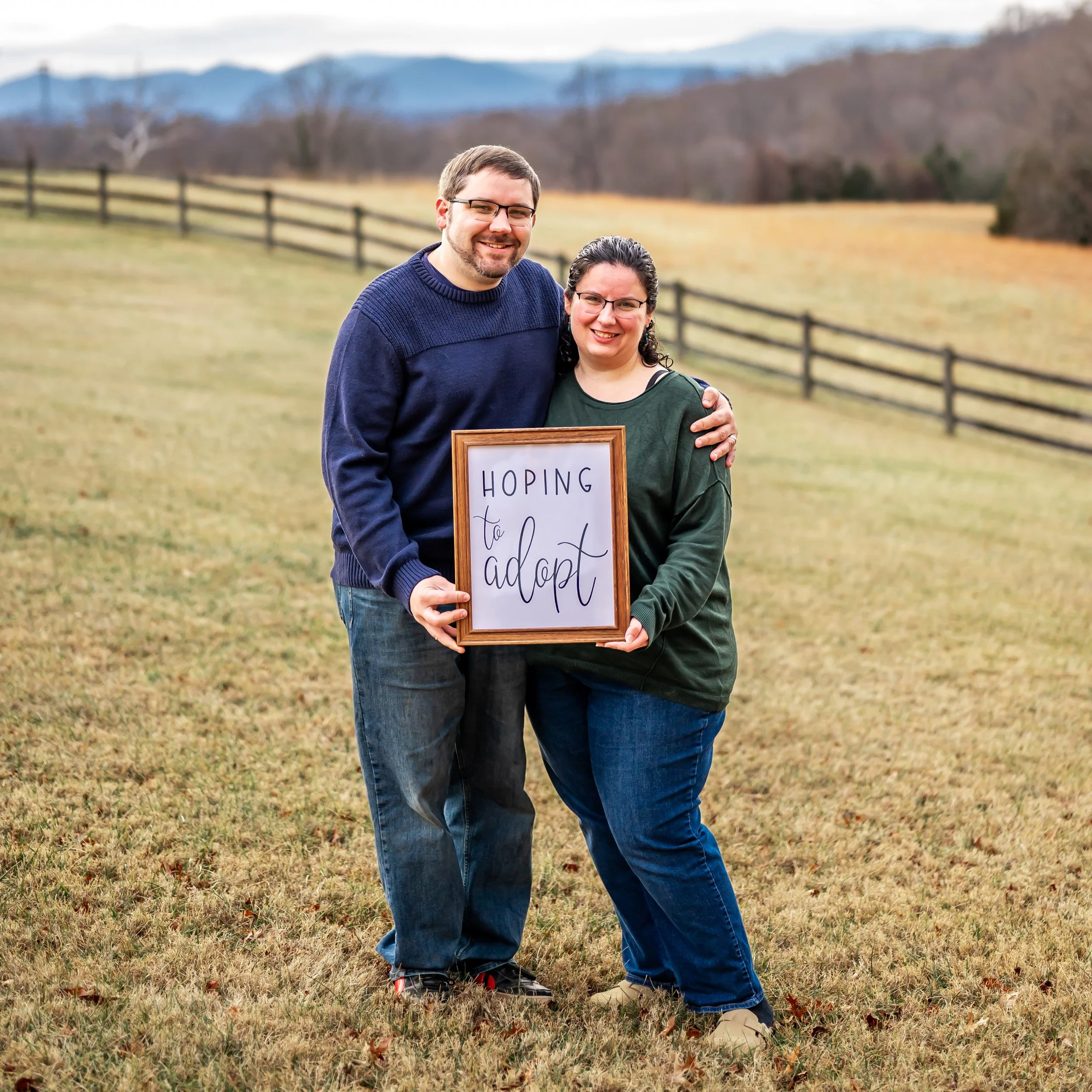 Brian and Katie holding a "hoping to adopt" sign