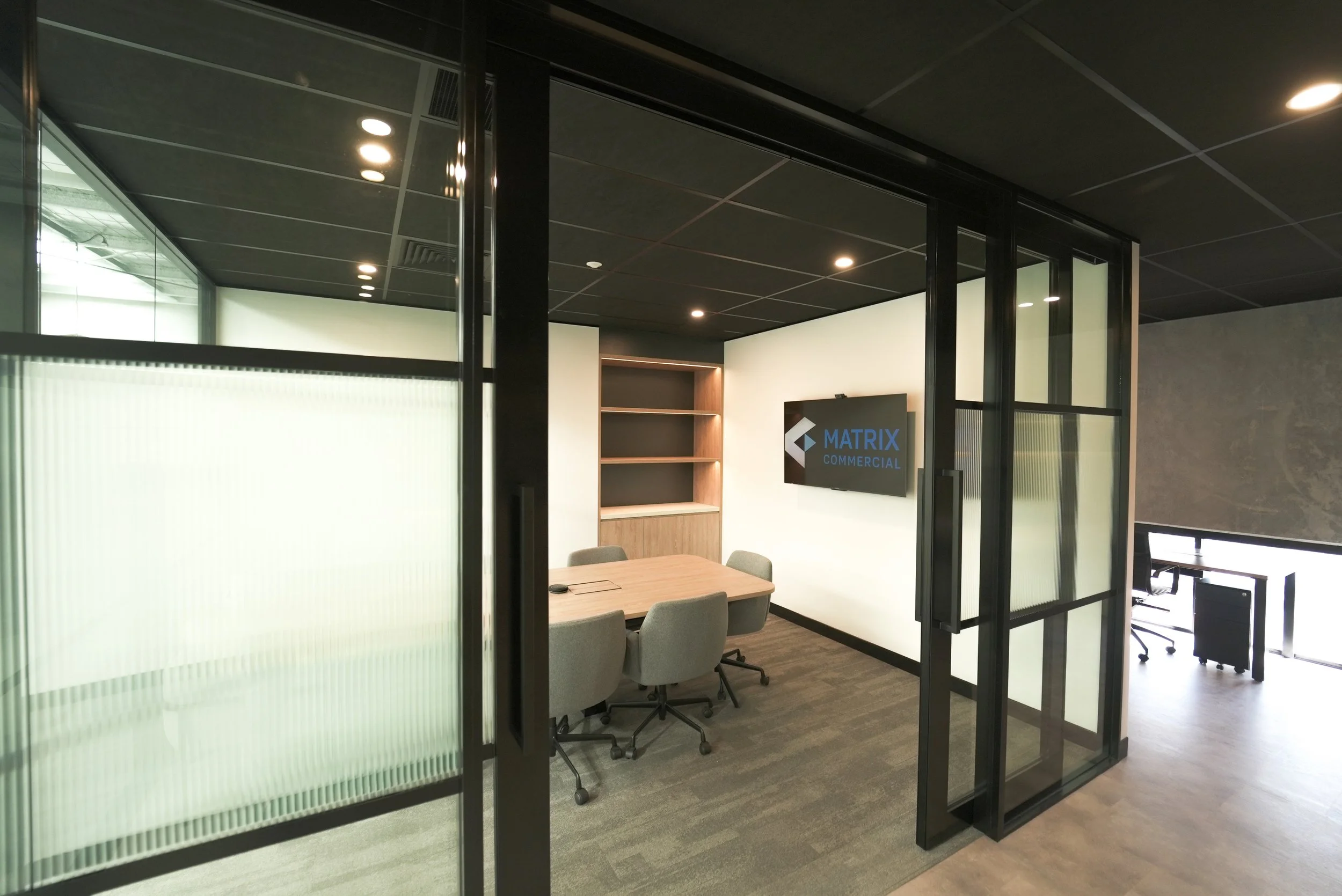 Innovync Office & Warehouse Fitout | Glass Meeting Room Design Brisbane

This Innovync office and warehouse fitout features a contemporary meeting room designed with black-framed glazed partitions, frosted privacy panels, and an acoustic ceiling to c