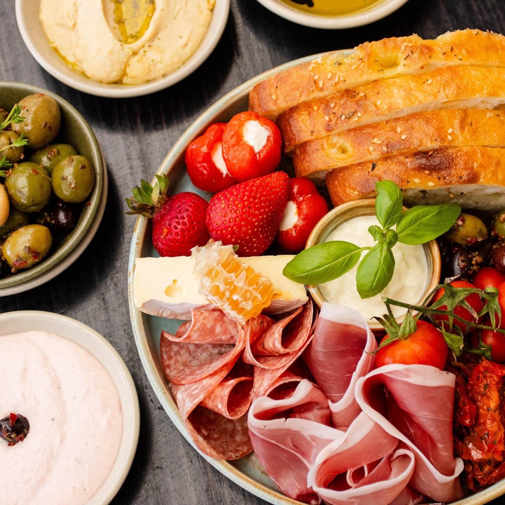Charcuterie board with olives and dips