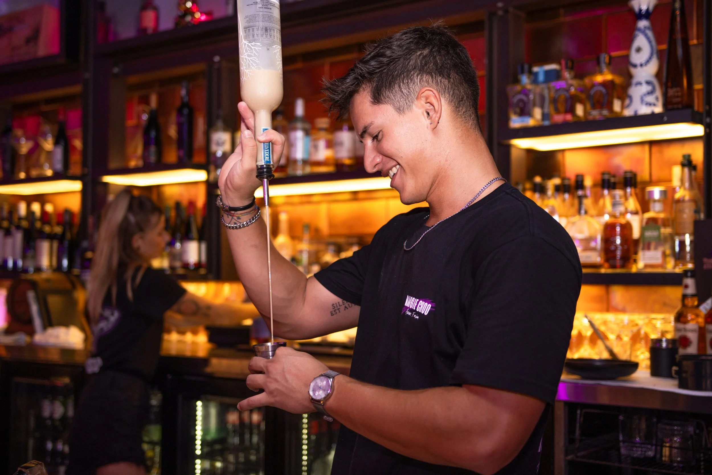 Bartender smiling making a cocktail at Maggie Choo