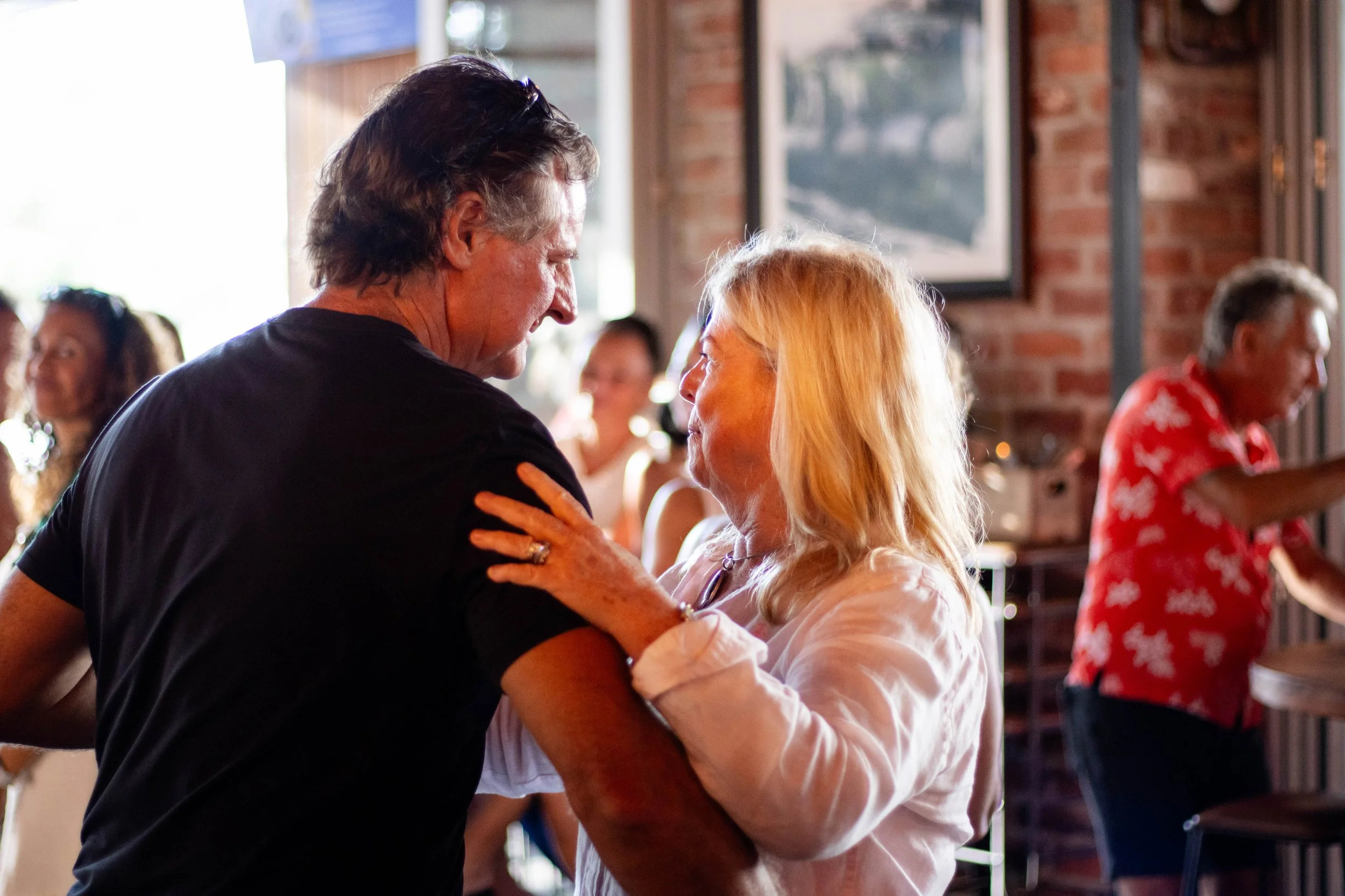 A couple smiling and dancing together at the loose moose on valentine's day