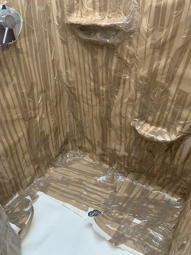 Taping up her bathroom and then later removing.