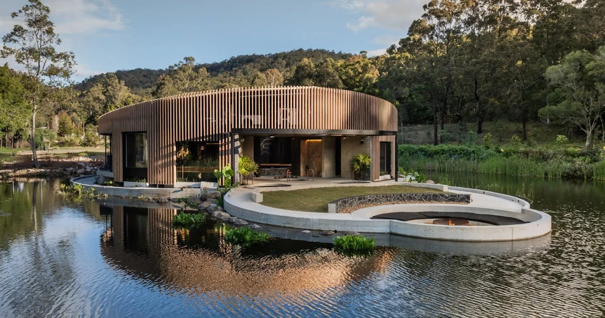 A small waterfall flowing into a rocky pool surrounded by lush green forest.