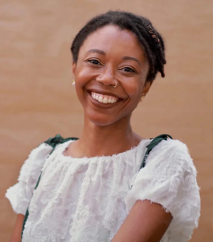 Elodie Edjang, a Black woman with a nose ring smiling