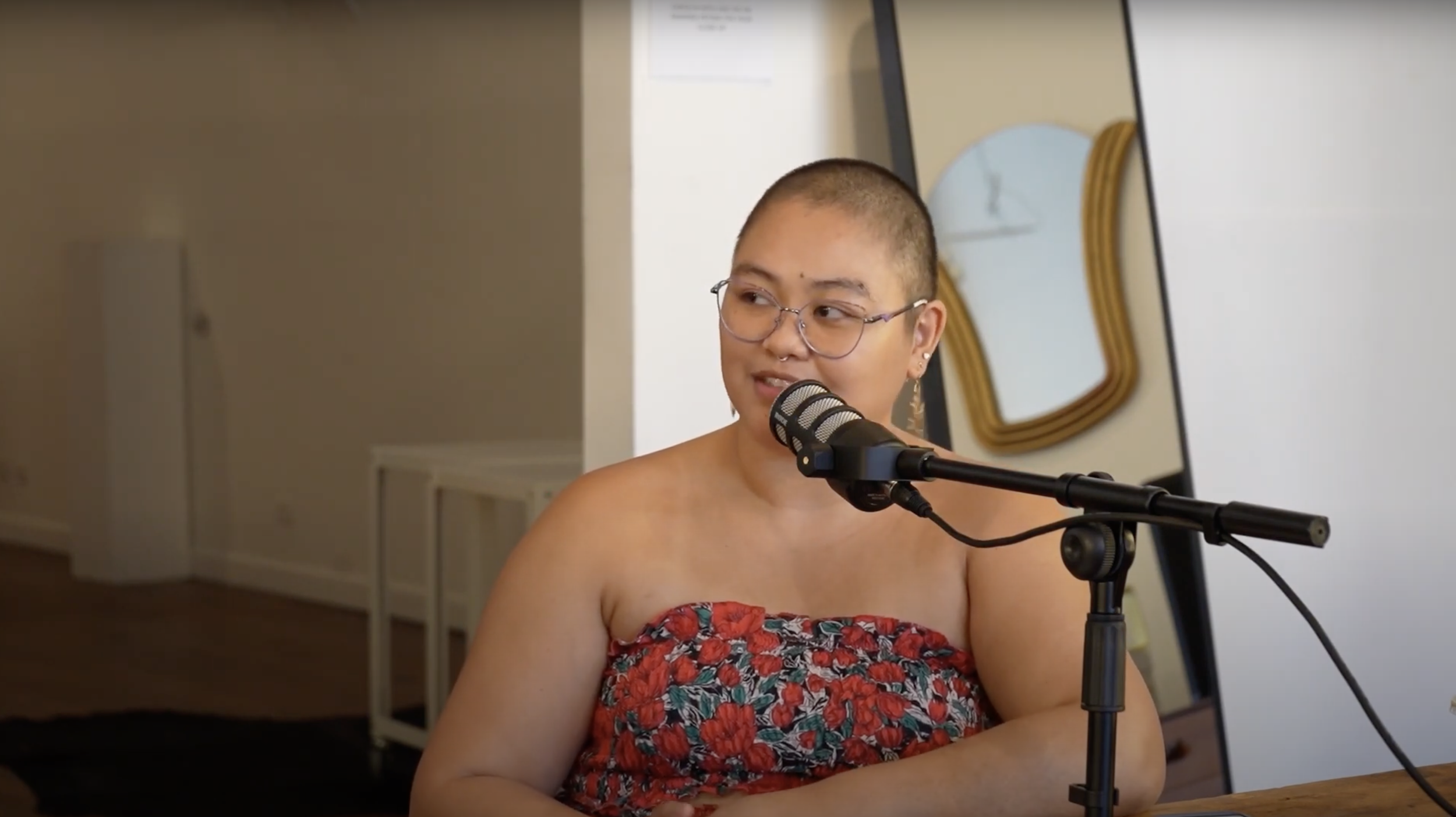 Regina speaking into a podcast microphone.