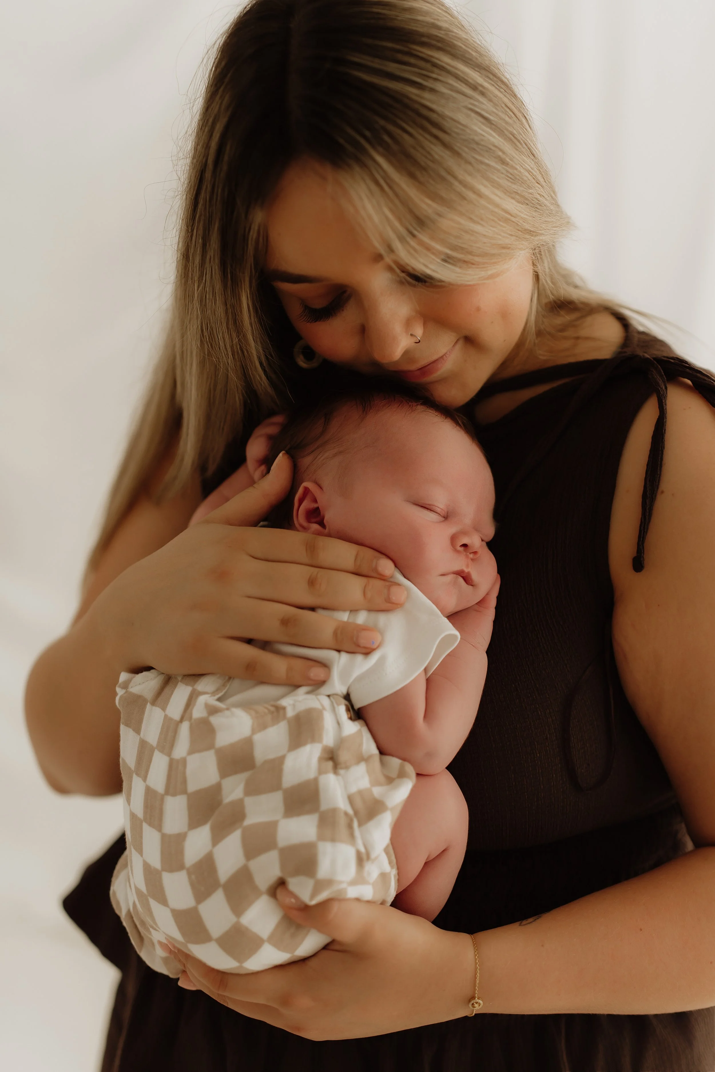 mum holding baby curled up on her chest