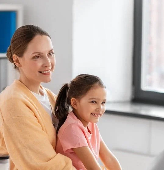 Tochter sitzt auf dem Schoß der Mutter beim Erstgespräch