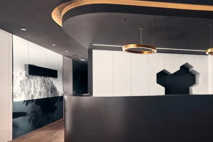 Designorientierte Zahnarztpraxis von Dr. Claudia Pinter in Wels mit dunklem, stilvollem Empfangsbereich.