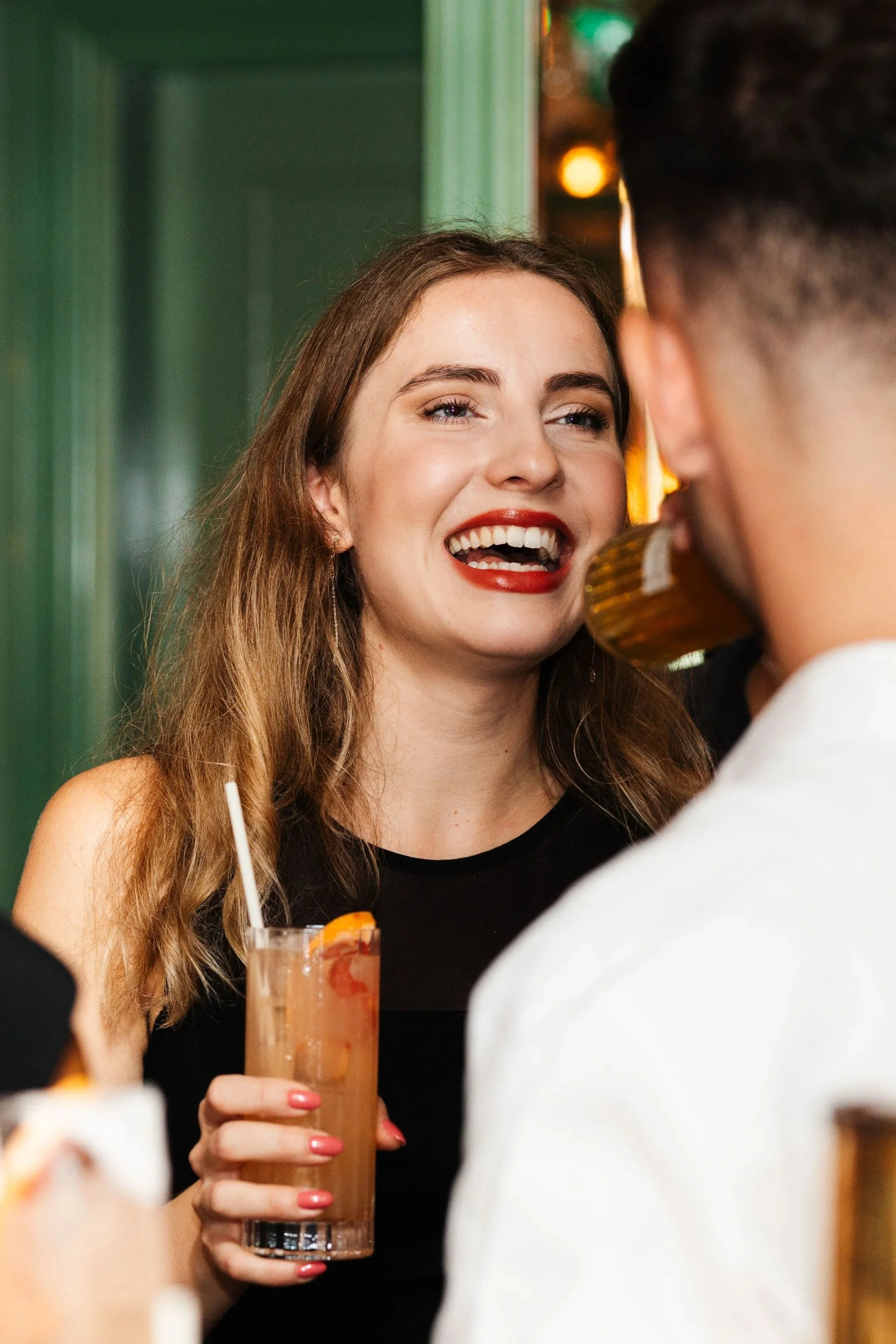 Guests laughing with drinks at a corporate event