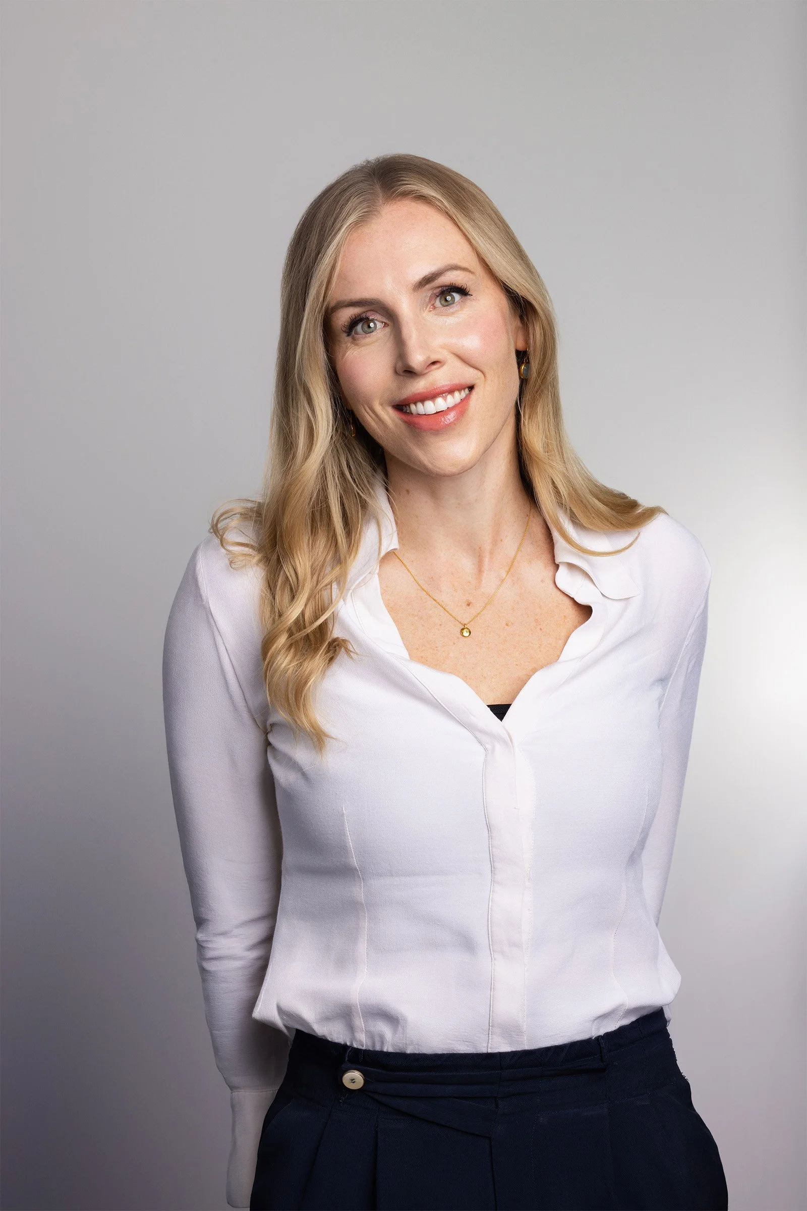 Corporate headshot of a smiling woman in a white shirt