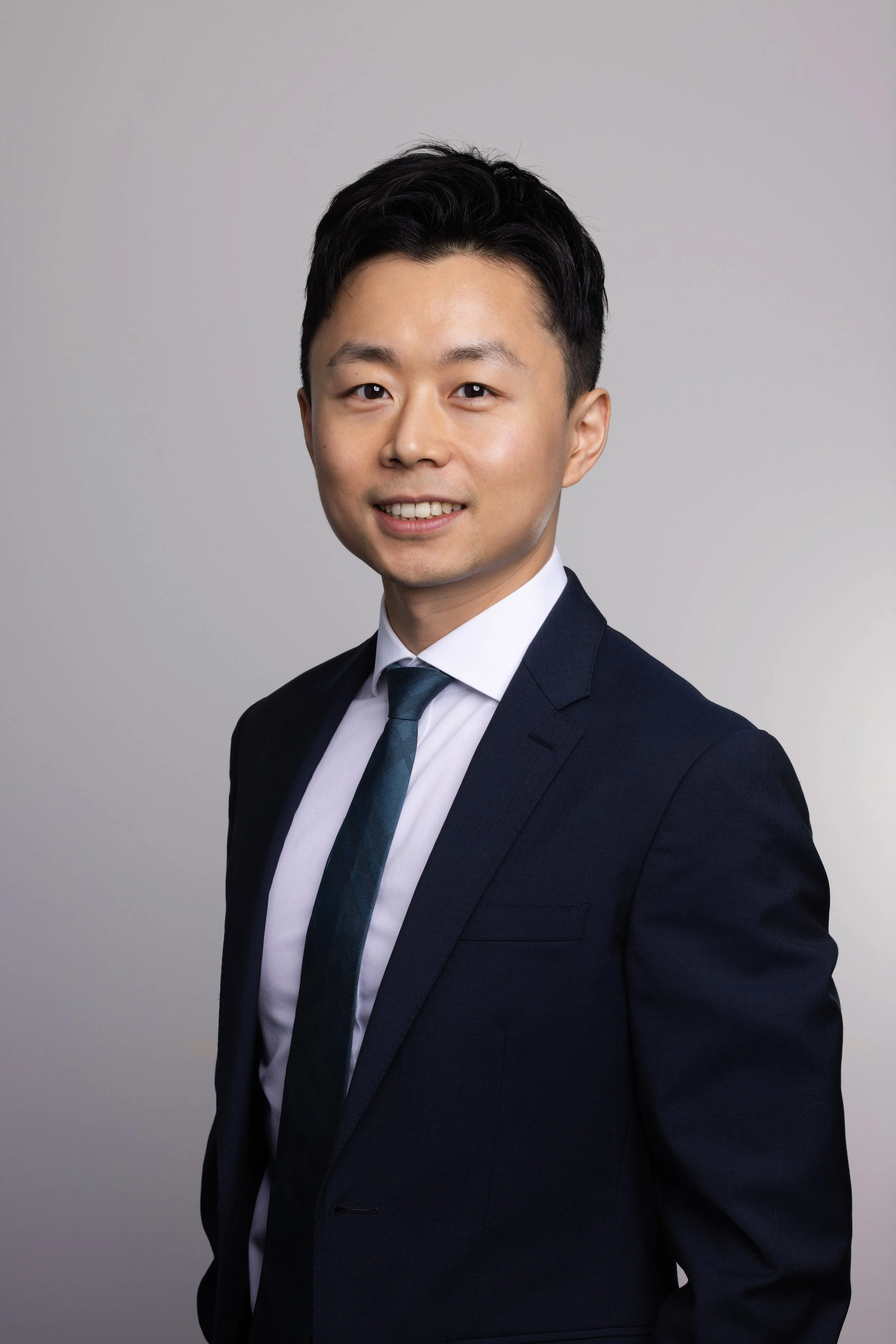 Corporate headshot of a man in a navy suit and tie