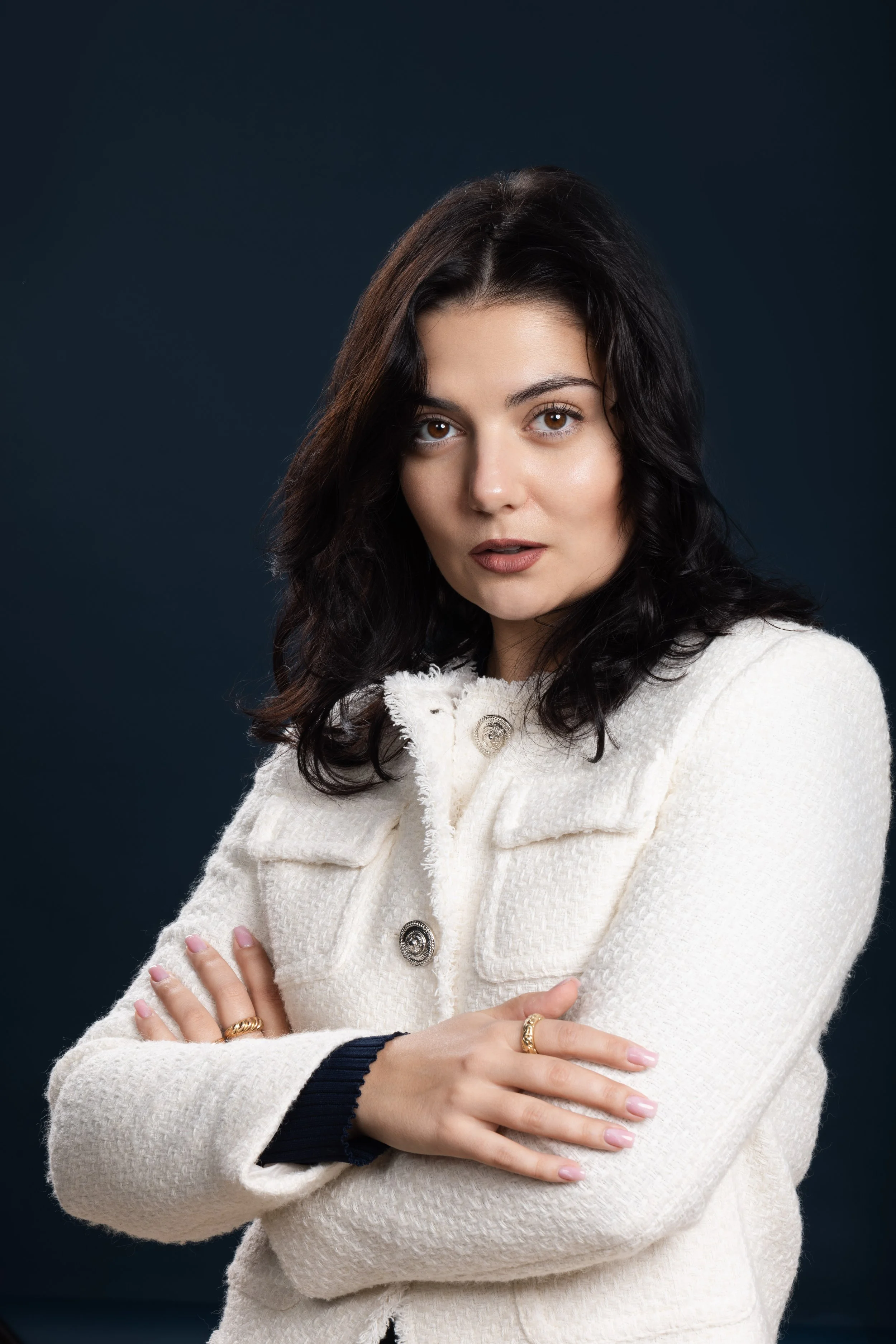 Corporate portrait of a woman in a cream jacket on a dark background