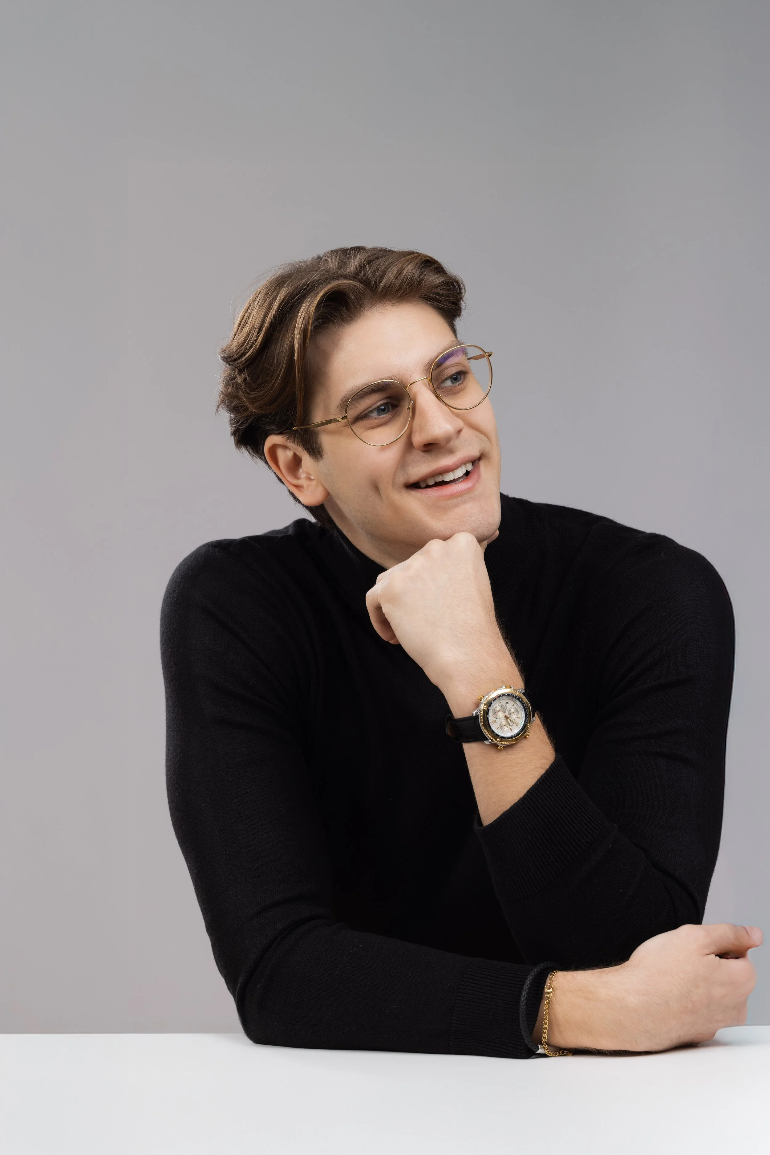 Relaxed corporate headshot of a man in glasses and a black jumper