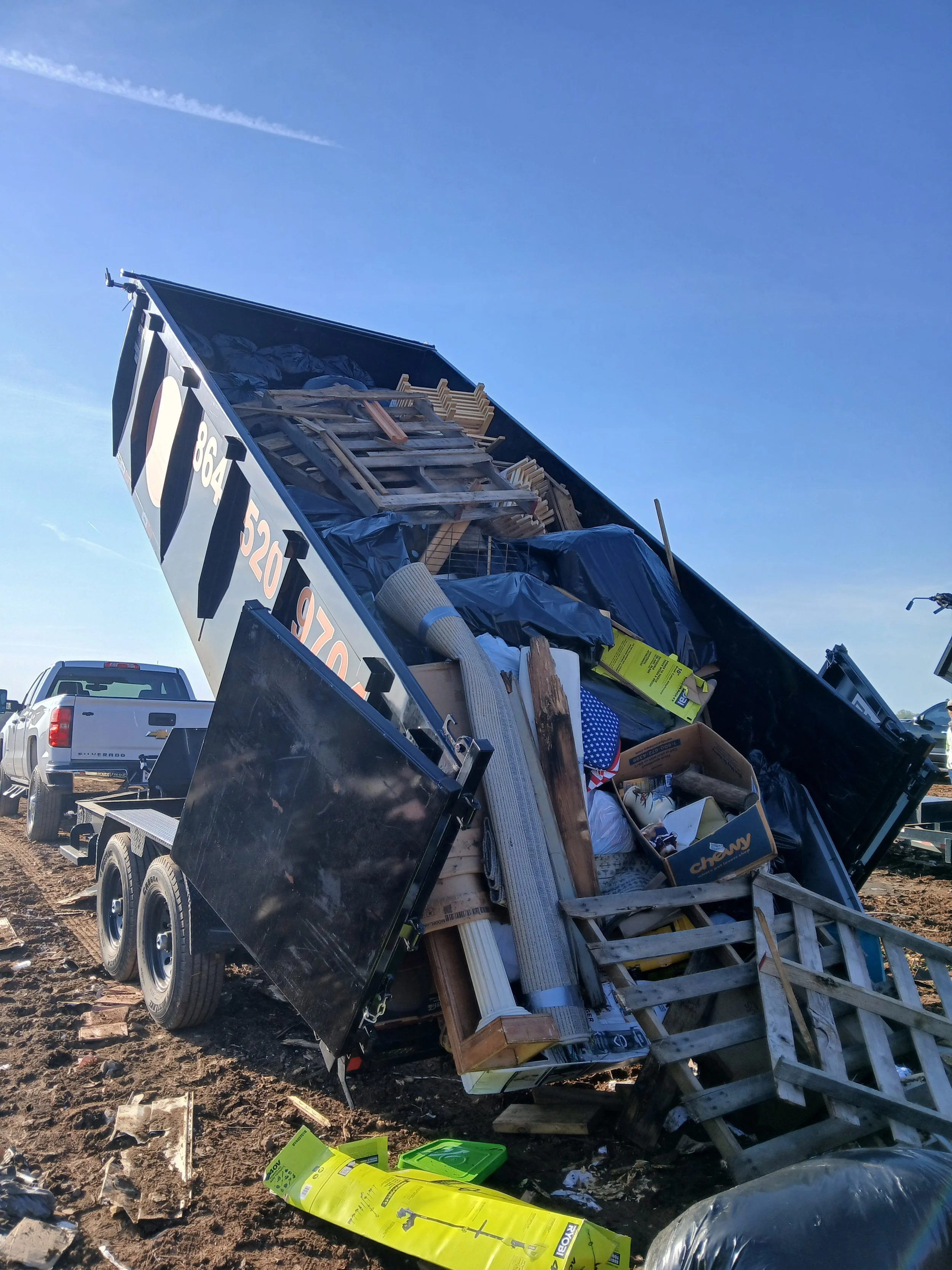 Dump trunck dumping commercial junk, like old pallets and old boxes.