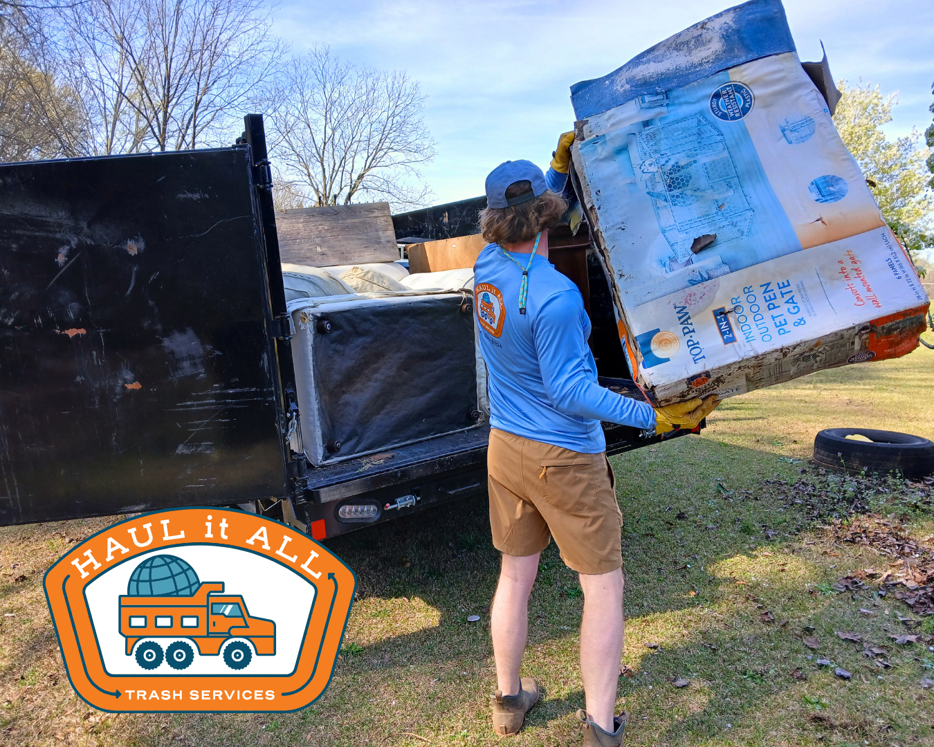 Man loading a dumpster with old household items and junk.