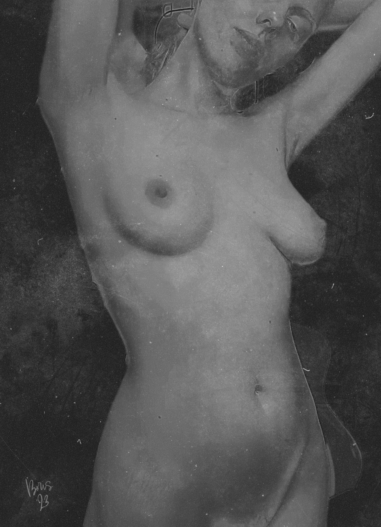 Black and white photo of a nude woman lying down with one arm raised above her head, looking at the camera, with glasses on her face.