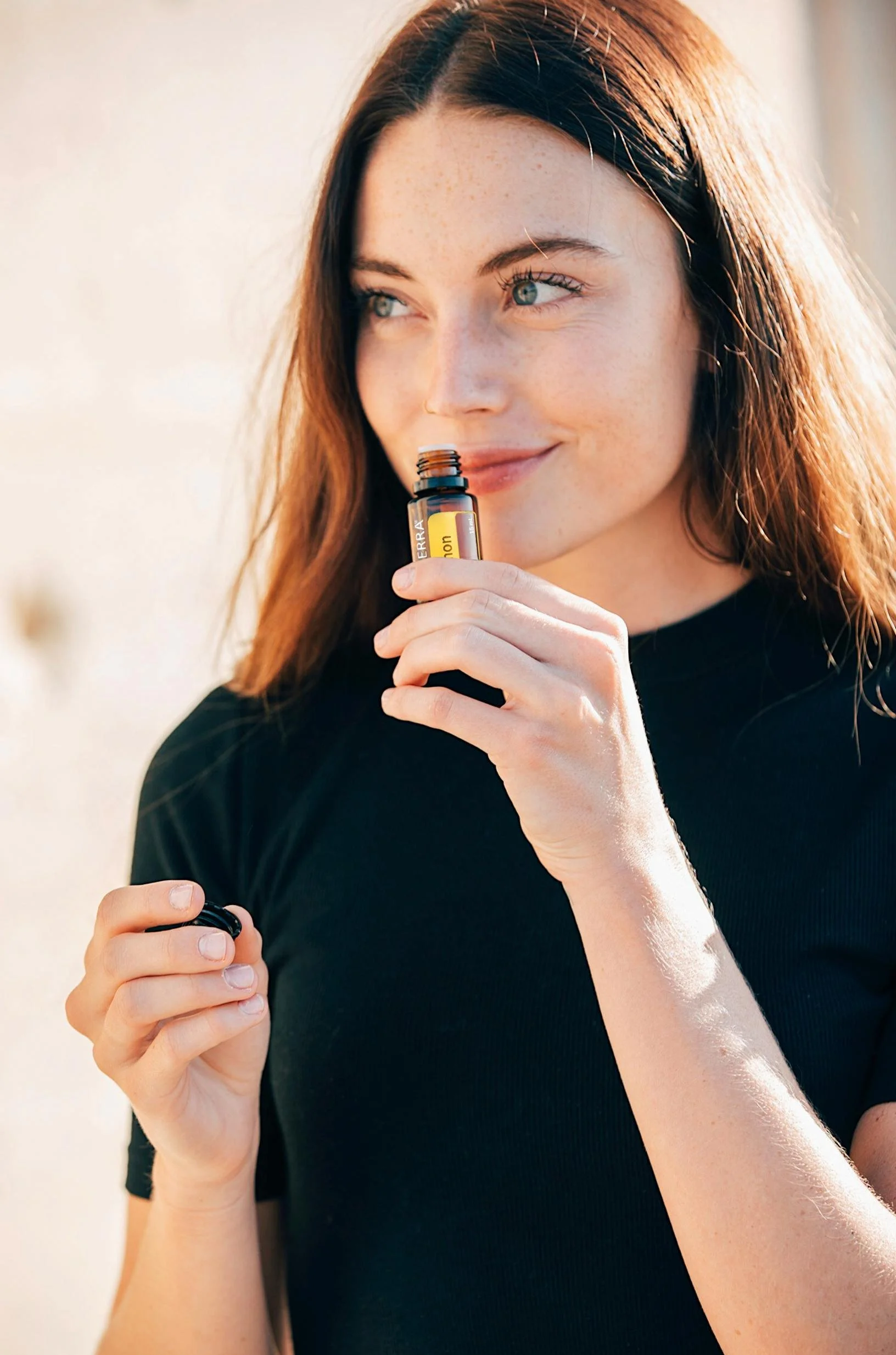Woman smelling essential oil bottle in fragrance consumer testing panel.
