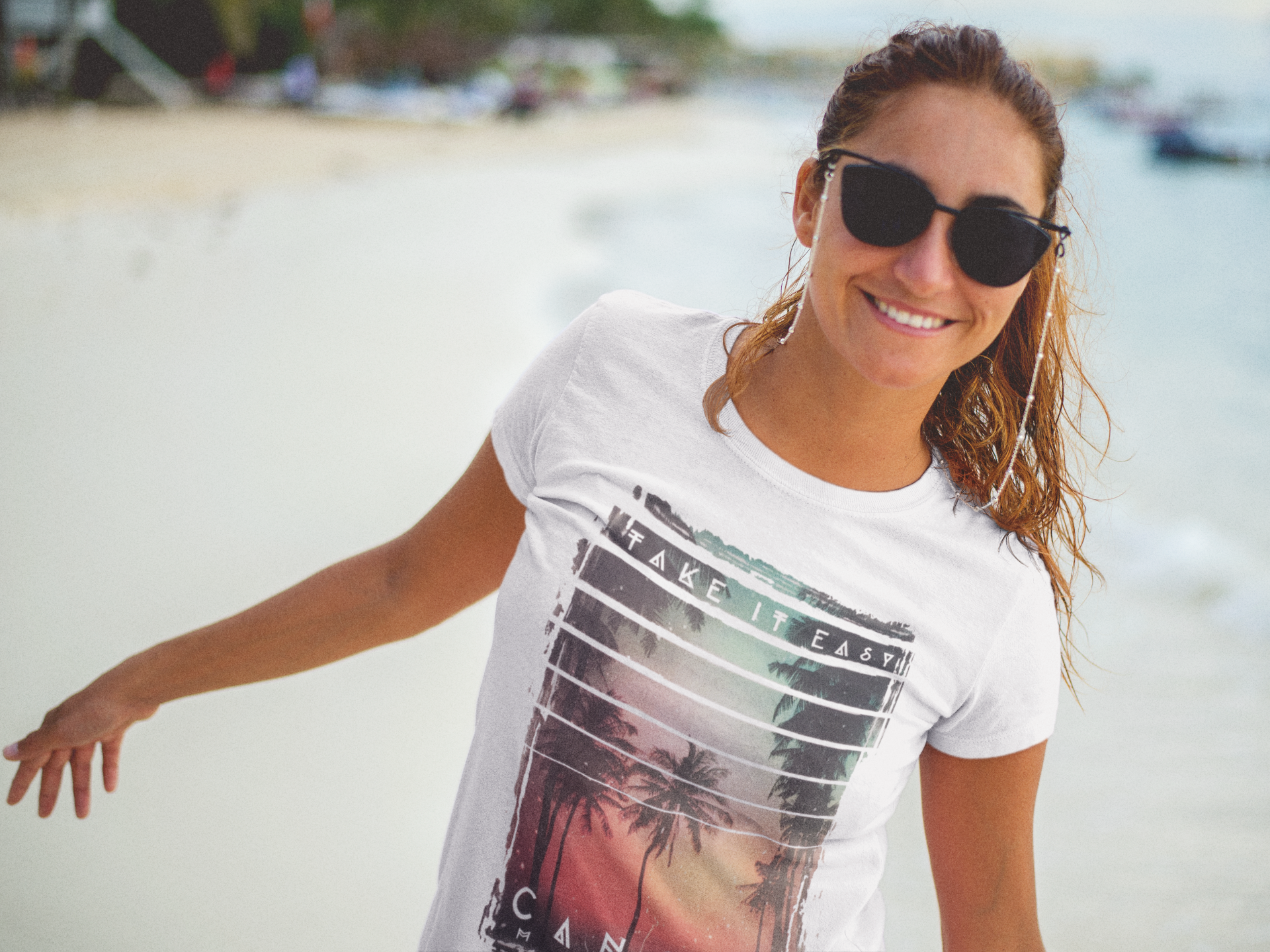 smiling-lovely-woman-wearing-a-t-shirt-mockup-and-sunglasses-at-the-beach-a12725.png