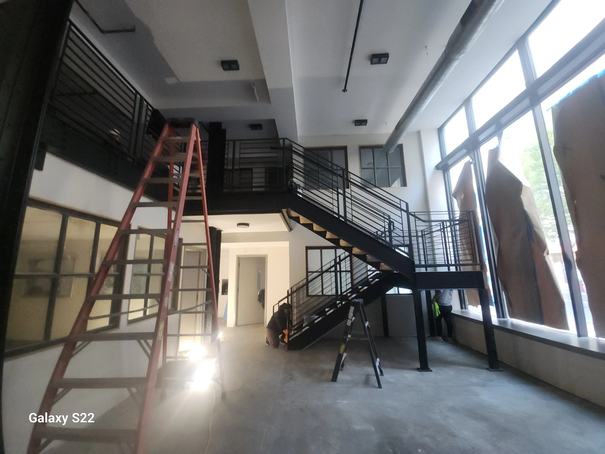 Custom metal staircase and railings inside a building under renovation.