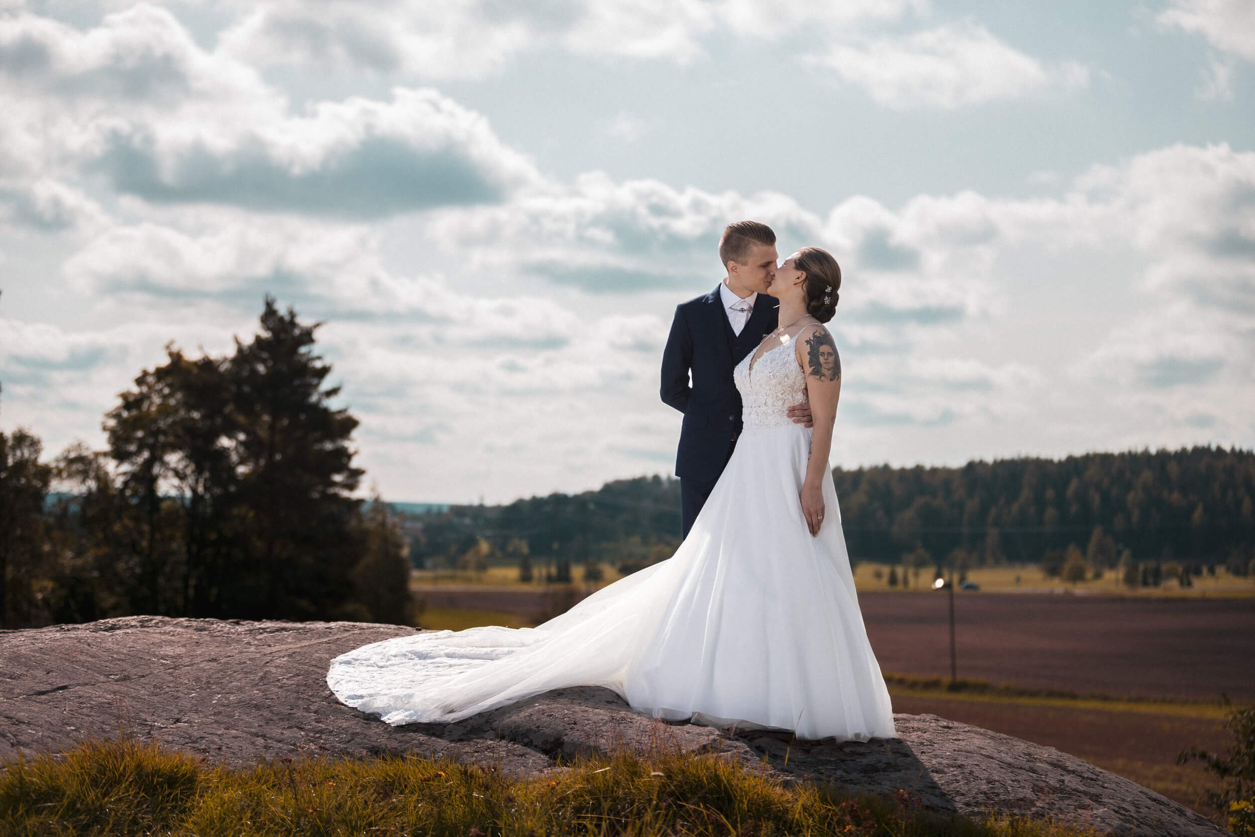 mies ja nainen suutelee hääasuissa