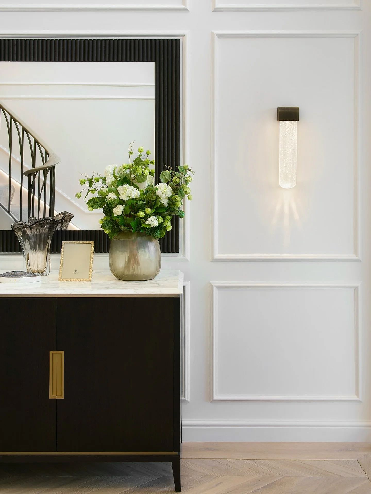 A space full of contrast, depth and small details that slowly reveal themselves the longer you spend in the space. 

The sideboard elevation in this beautiful entrance hall is a classic, a custom-made sideboard, the structure of which was designed to
