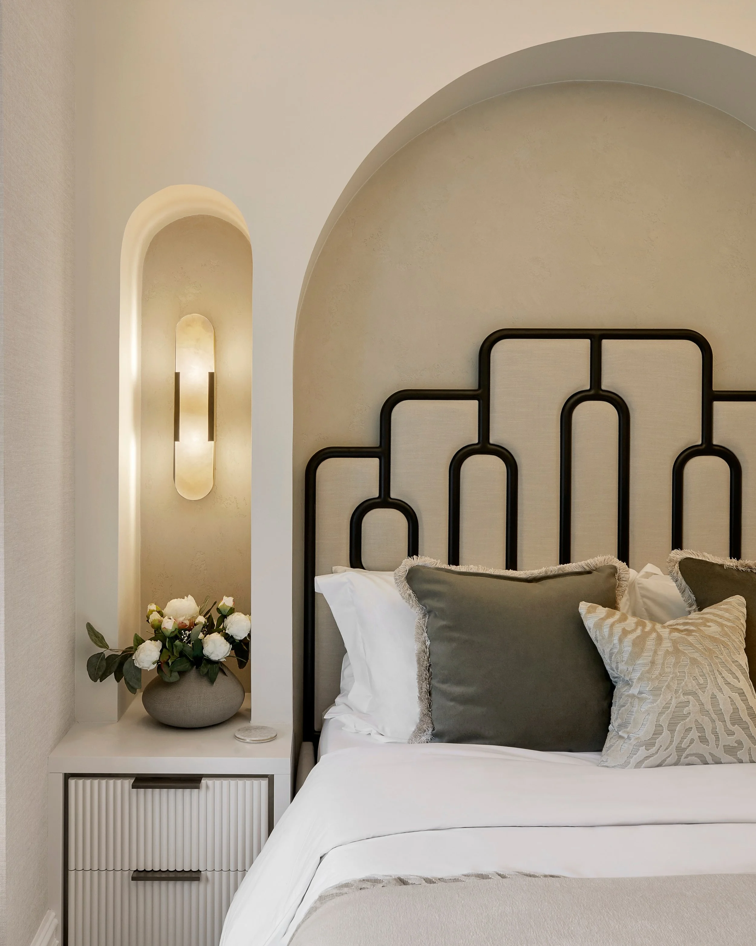 This guest bedroom situated in West Minster was designed around the art of layering.

Integrated watched niches frame the bed to create a strong architectural focal point, whilst softly enveloping the bedside lighting the creamy a warm, cocooning ton