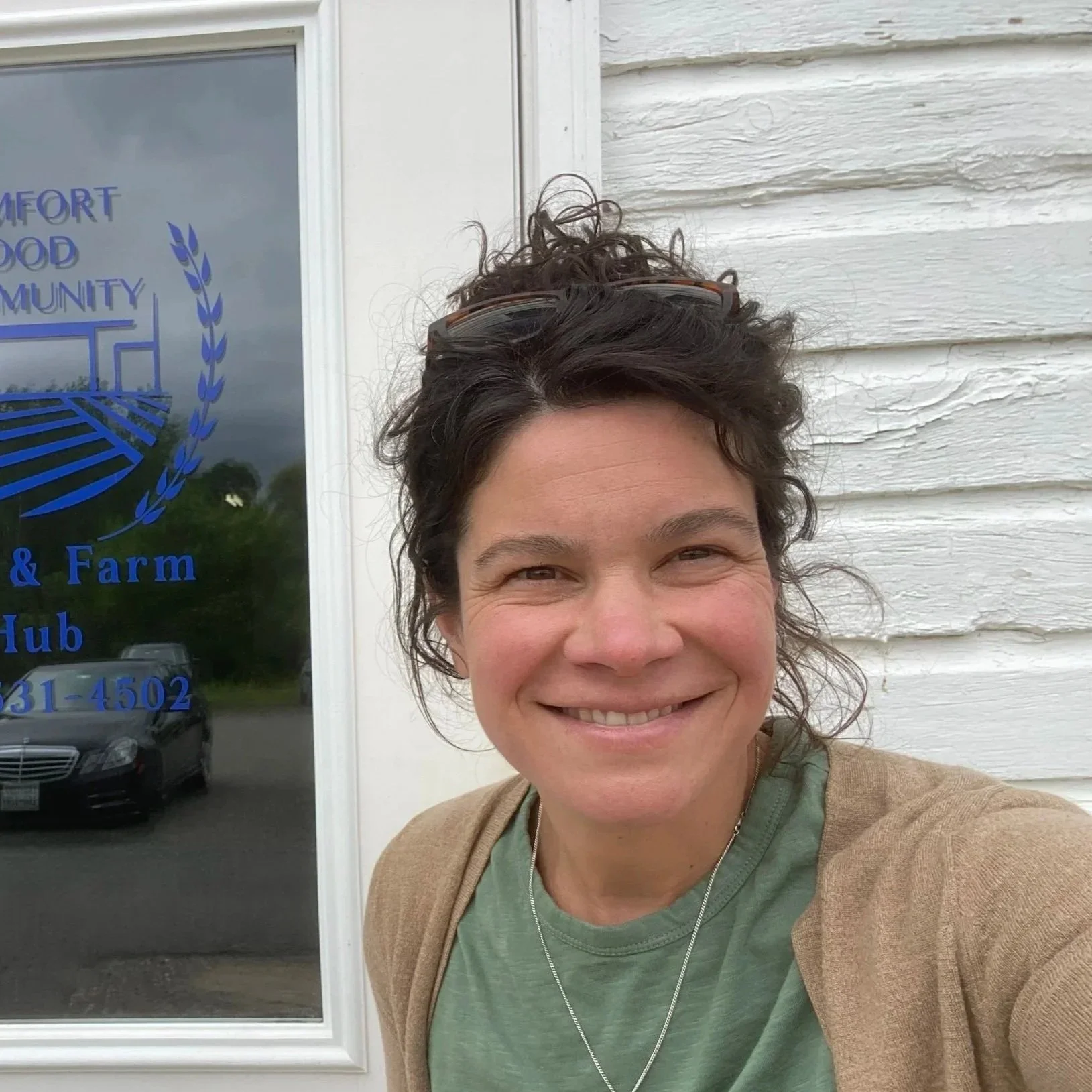 Photo of Annie in a green shirt and tan sweater.