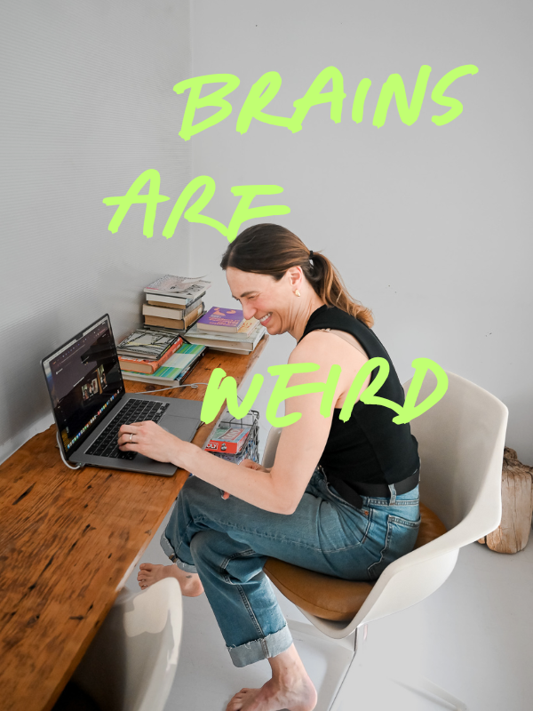 Woman sitting barefoot at a desk, smiling, with books and a laptop, with neon green text reading 'Brains Are Weird' overlayed.