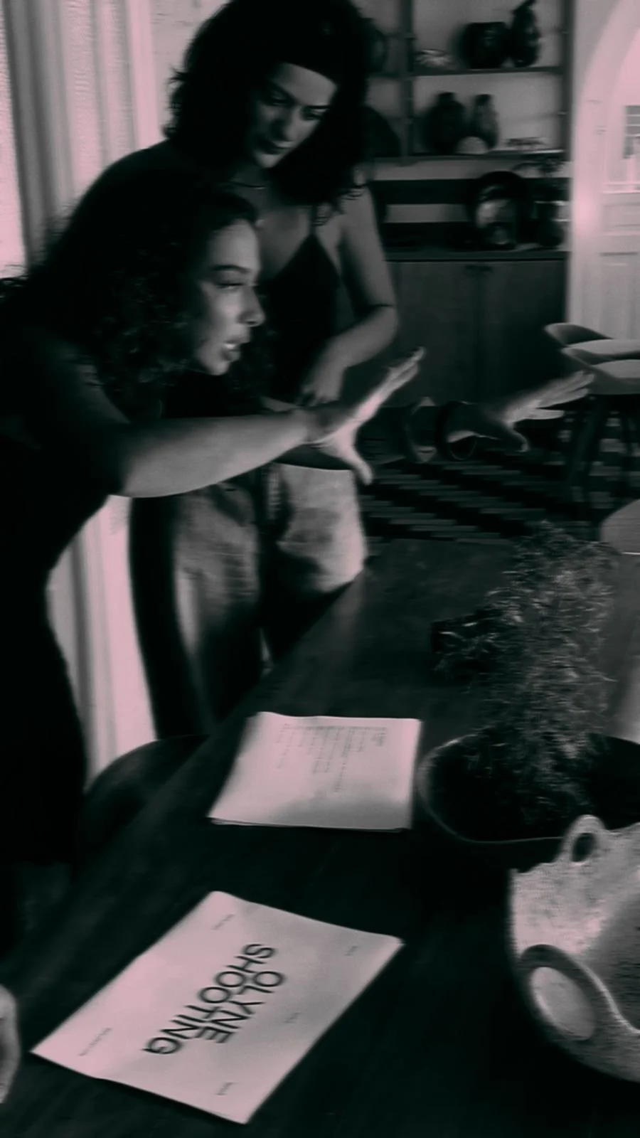 Two women at a dining table with birthday decorations, including a cake with sparklers, celebrating a birthday.
