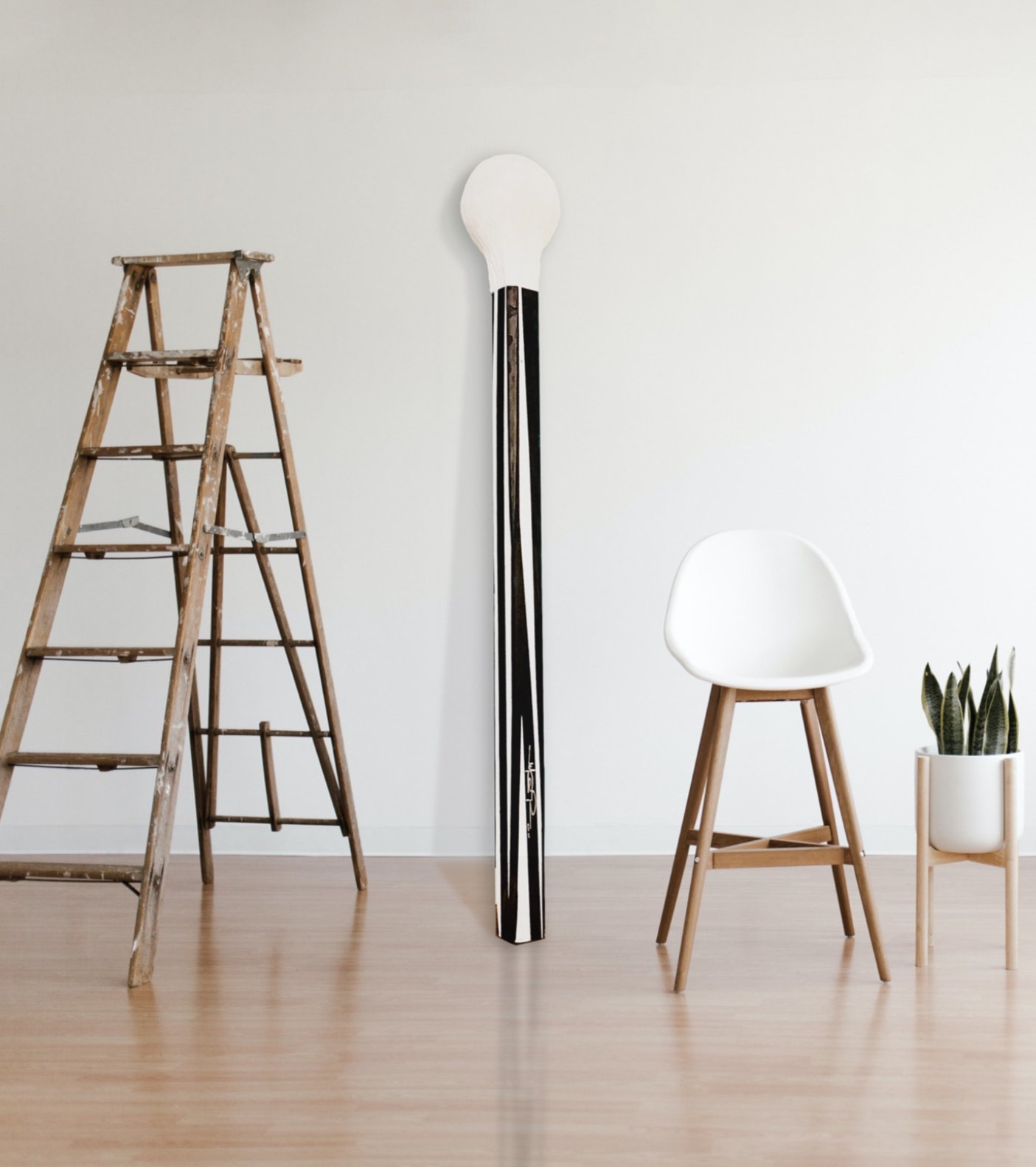 A wooden ladder, a tall sculptural object, a modern white chair with wooden legs, and a potted plant with long leaves on a light hardwood floor with a white wall background.