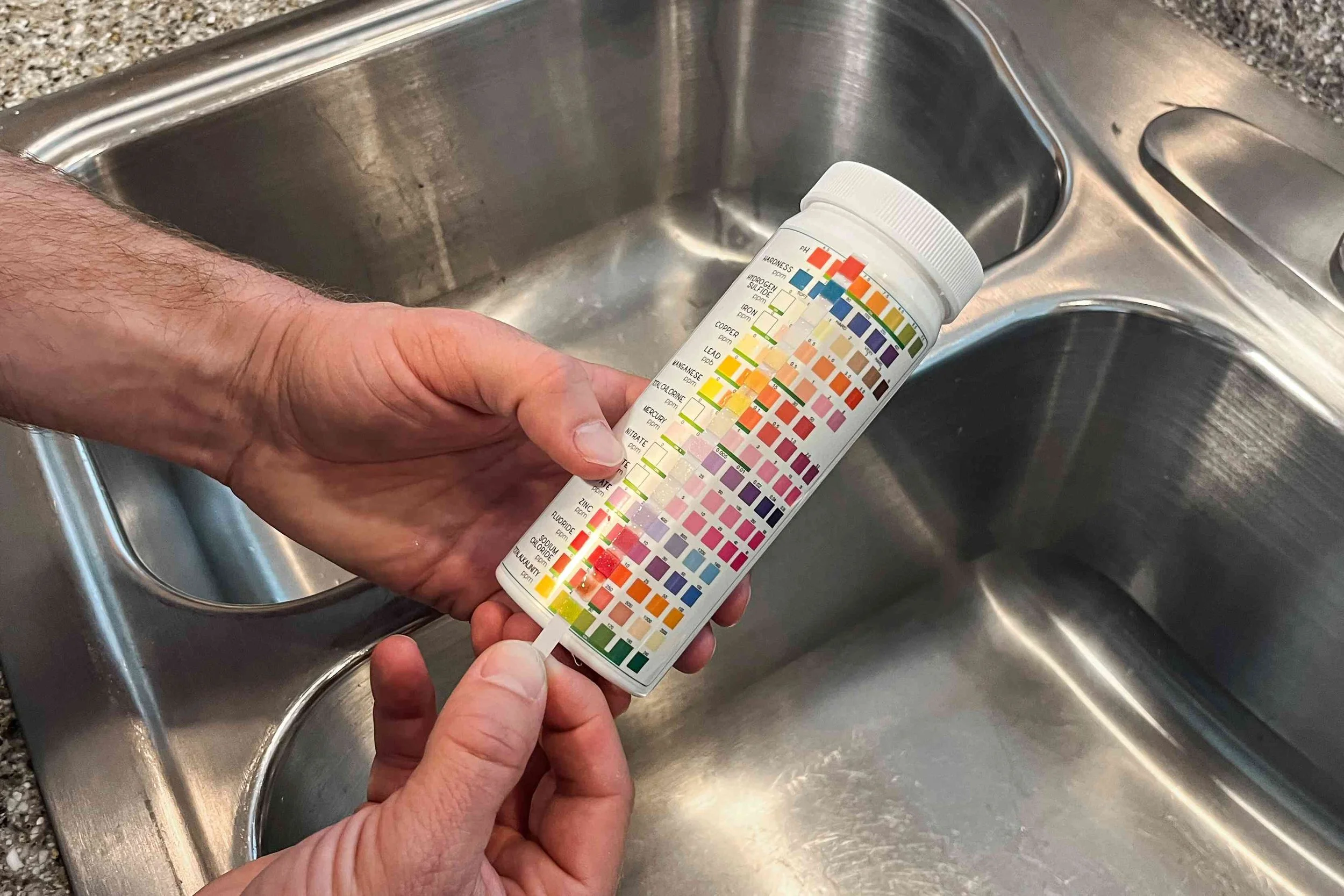 Someone using water test strips