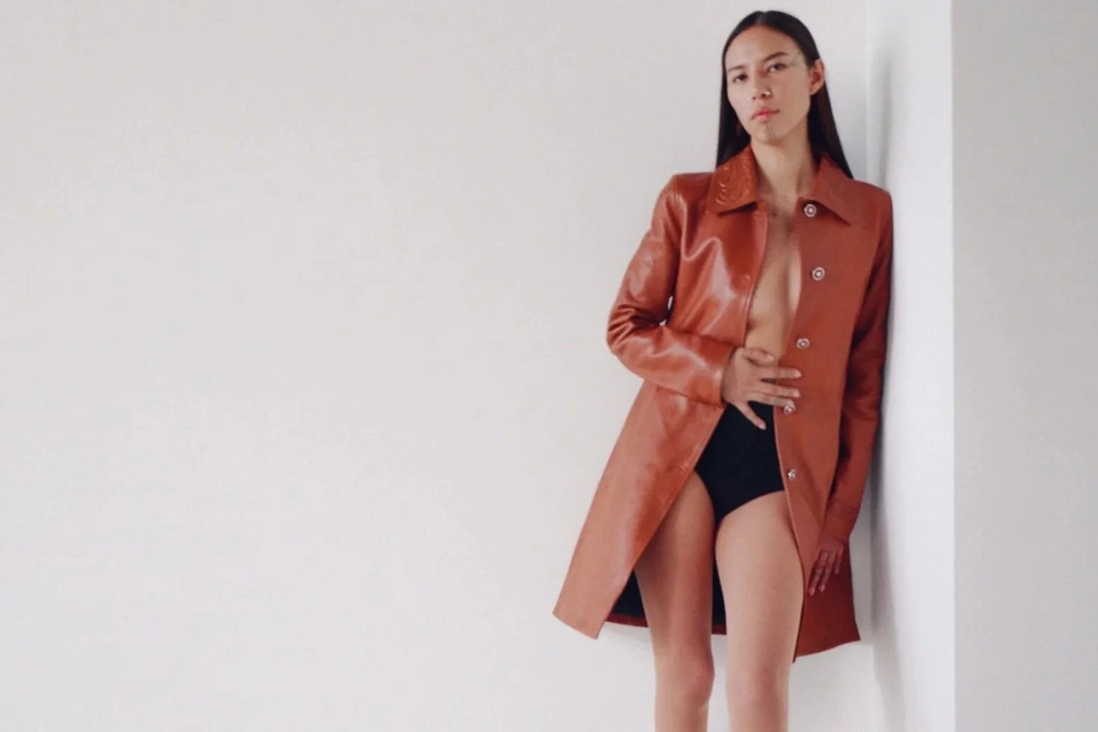 Model standing against white walls during a photoshoot in Los Angeles