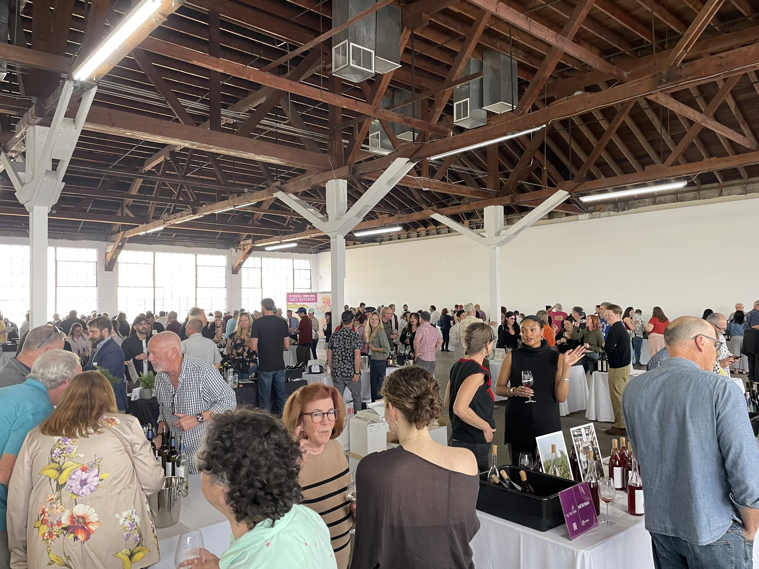 Large groups of people filling the venue during a wine festival at Mica Studios