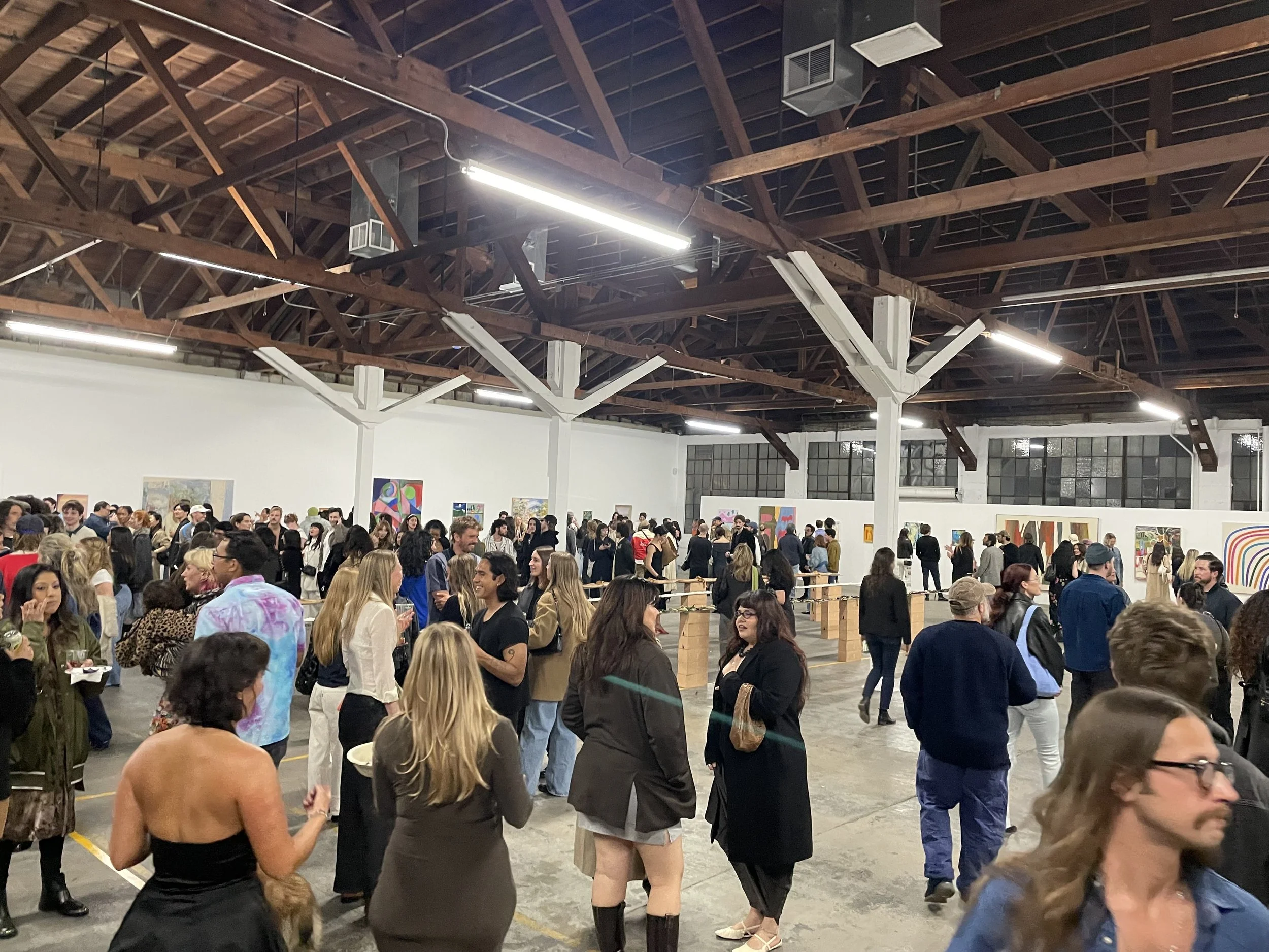 Showcasing people walking around an art gallery event at Mica Studios