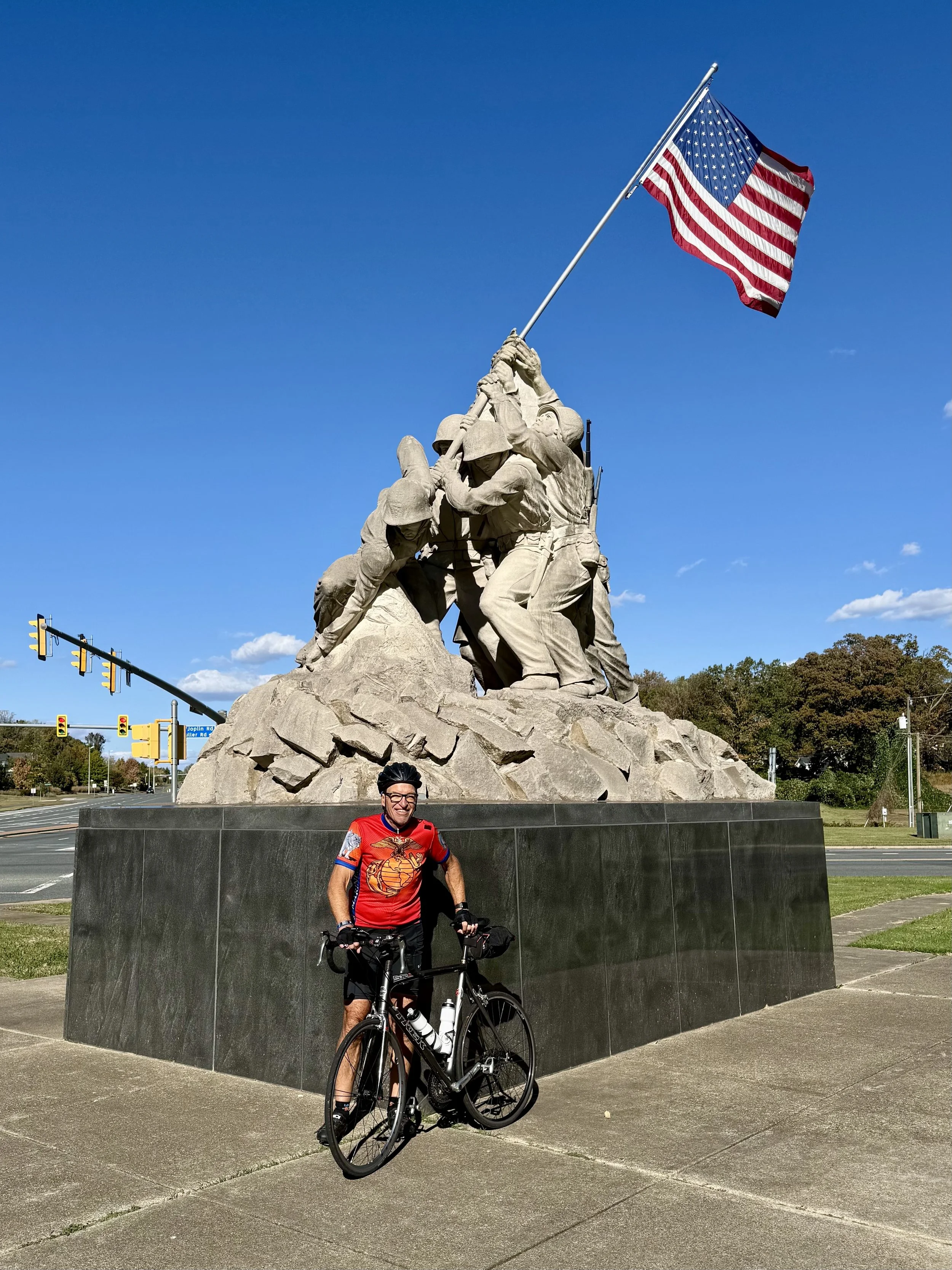 Jeff Simons wearing USMC cycling jersey at Iwo Jima memorial statue
