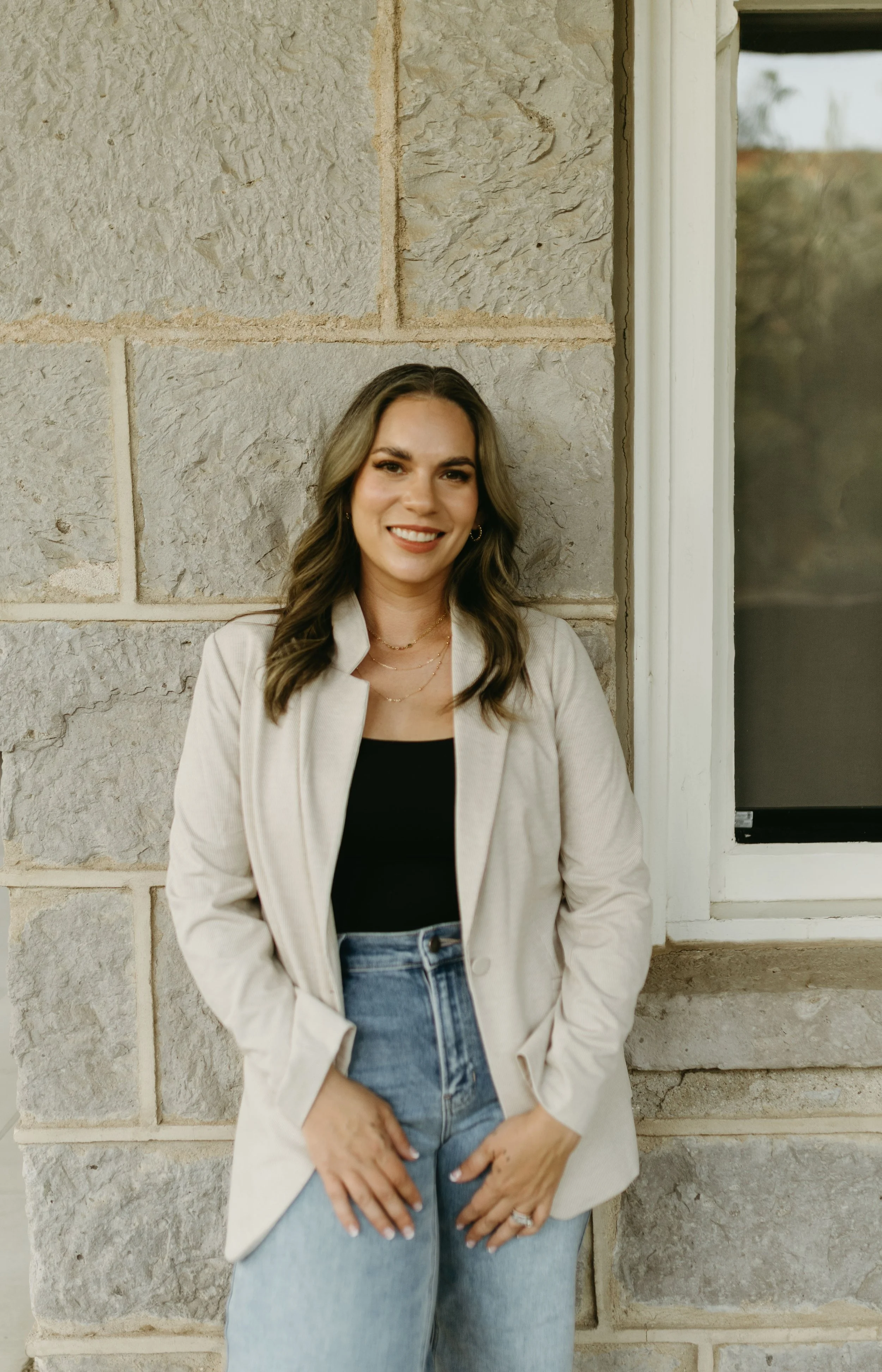 female therapist smiling at camera in front of building