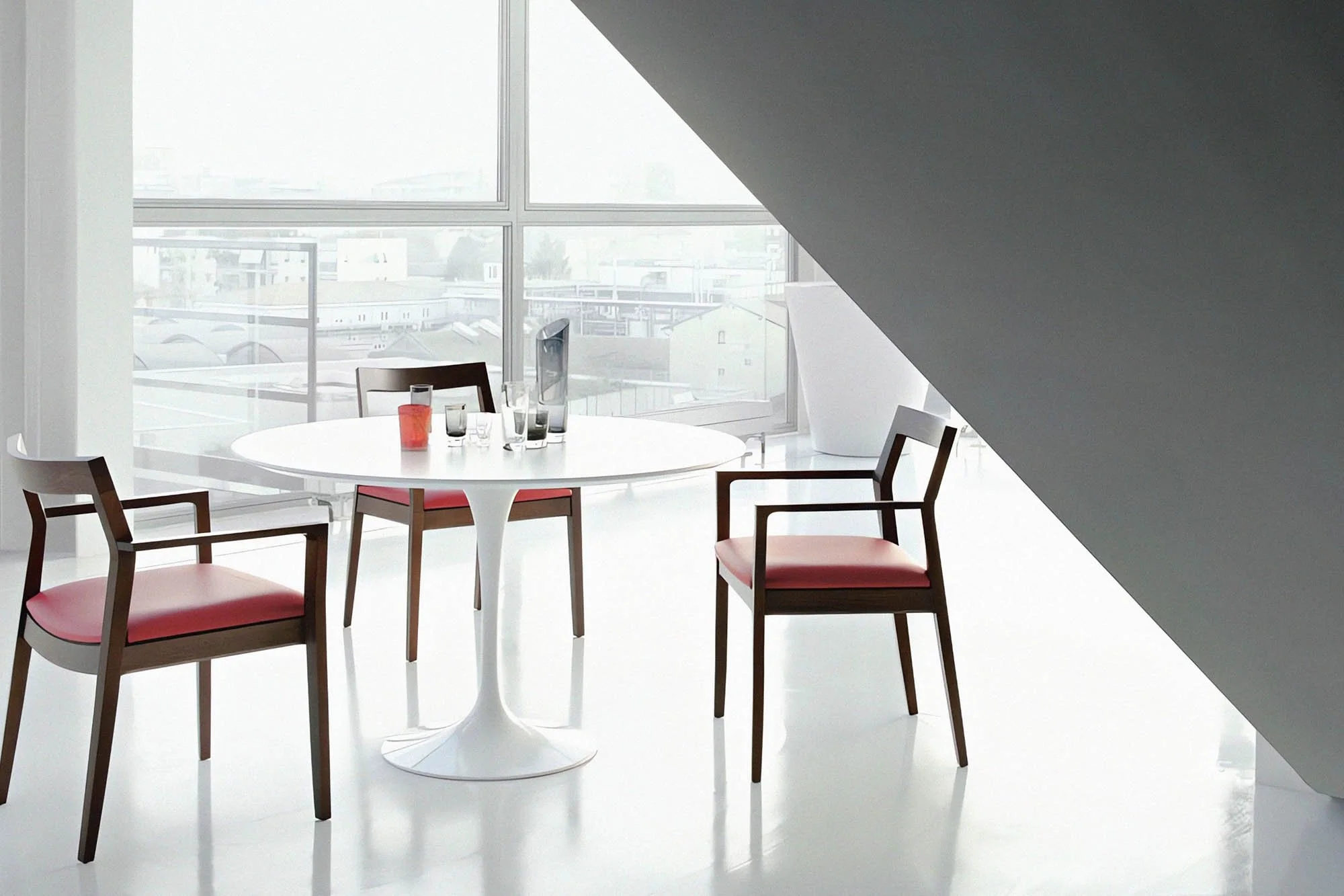 White Tulip Table with round white laminate top and pedestal base by Eero Saarinen, authentic mid-century modern dining table by Knoll for contemporary interiors.
