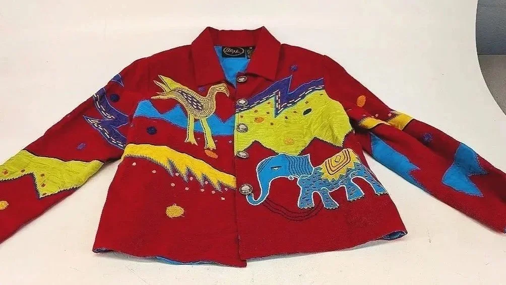 Red jacket with colorful embroidered animal designs, including a bird, an elephant, and abstract shapes.