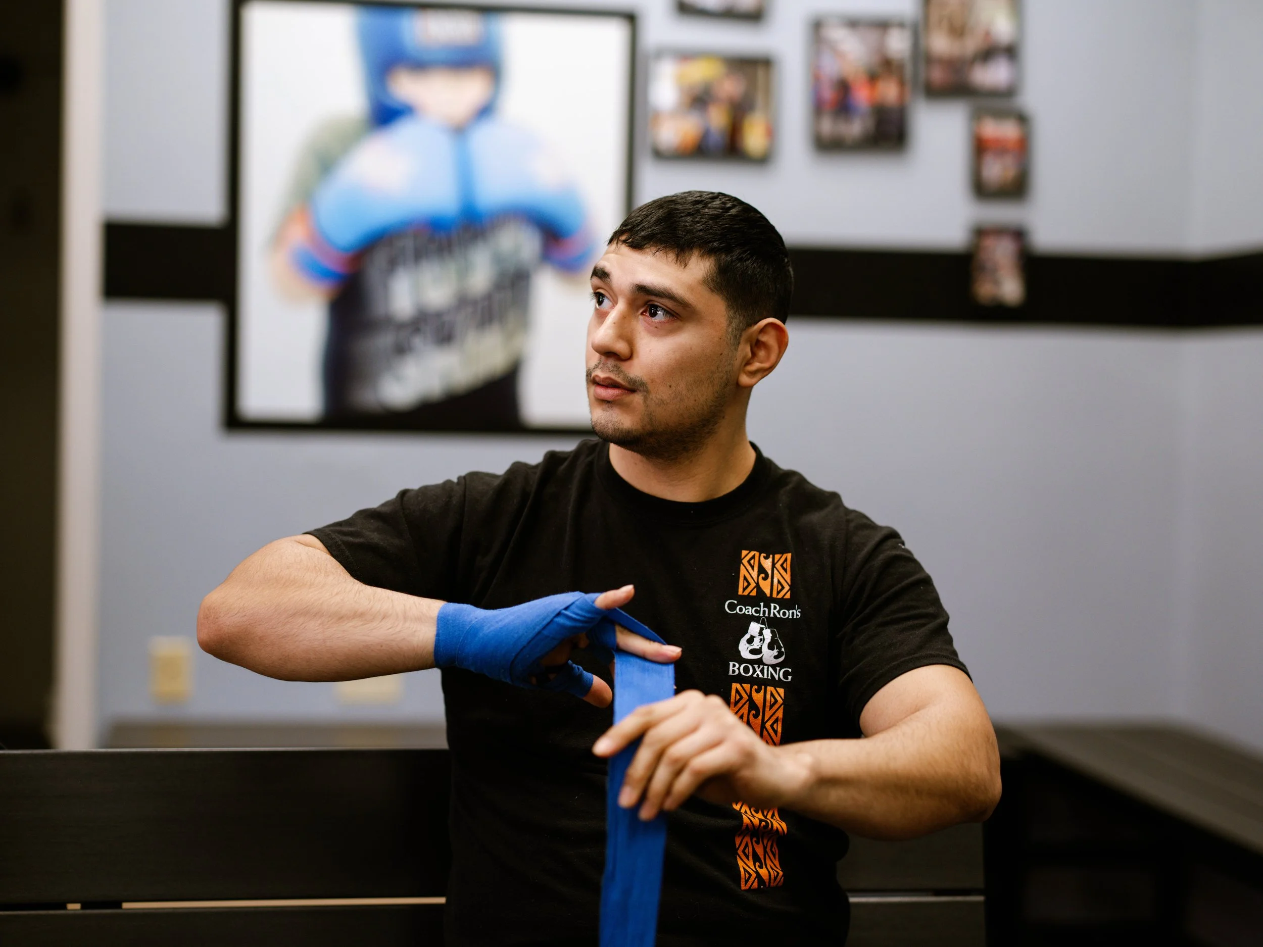 Boxer wrapping his hands with blue hand wraps before training