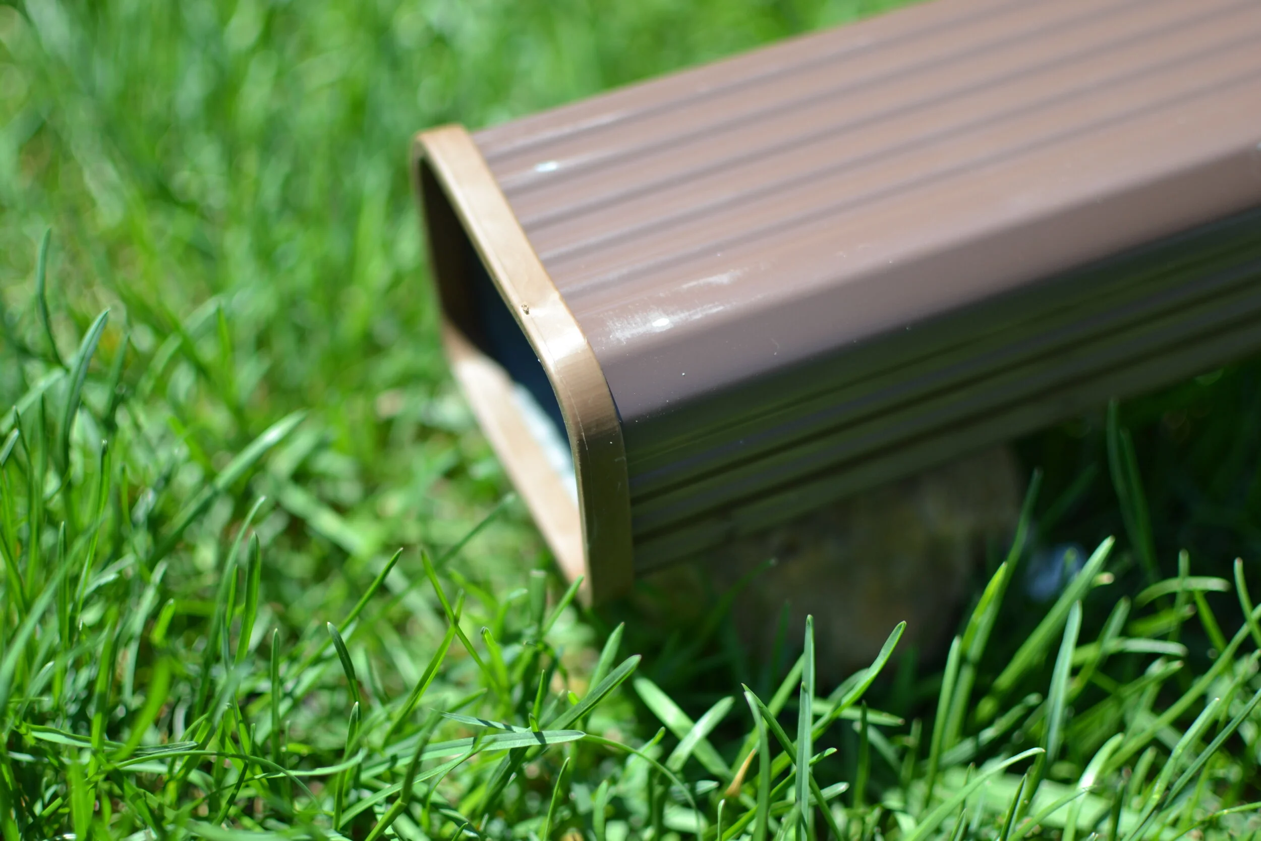 a brown downspout with a brown SpoutTrim cap cover