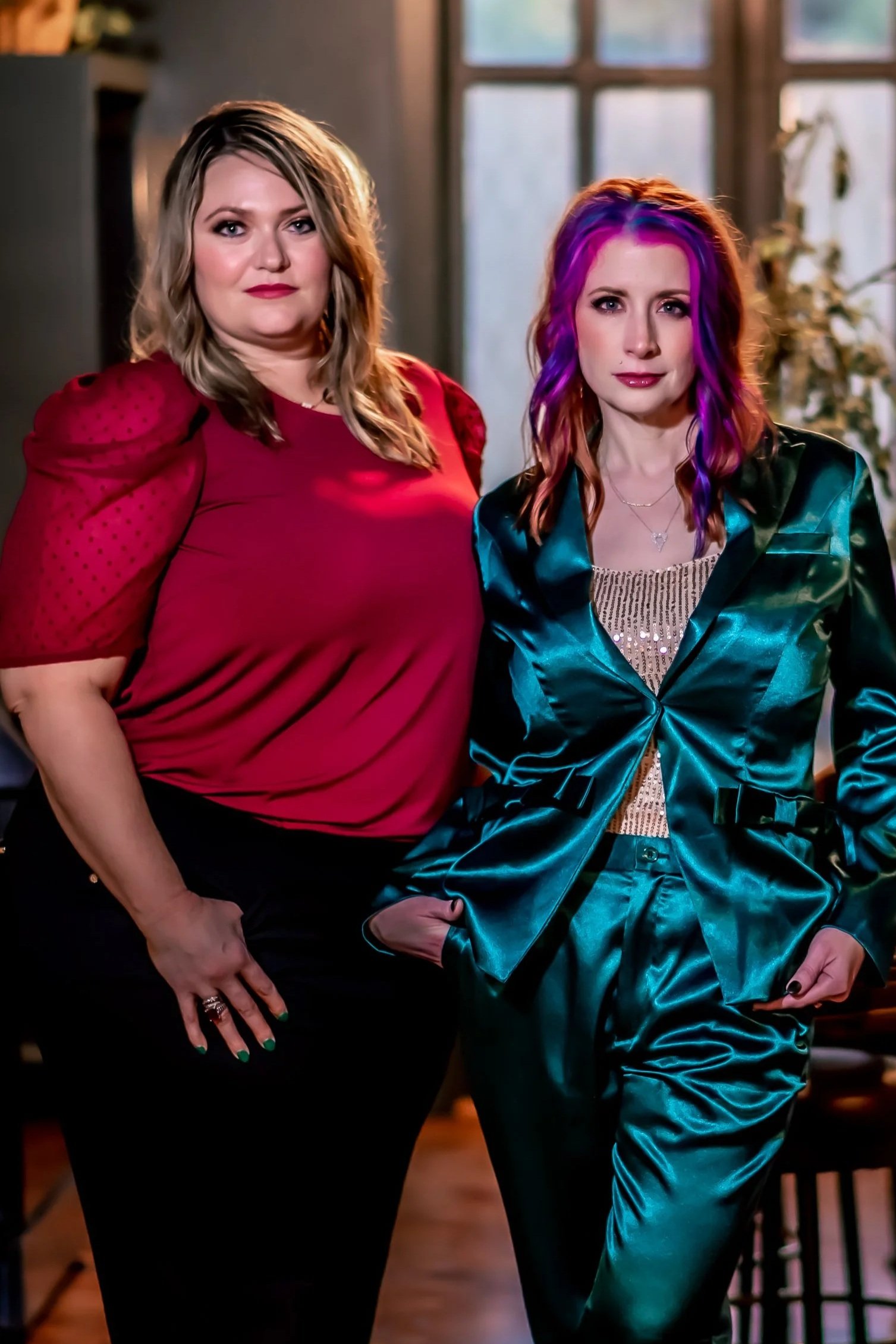 Dana Kausek, LCSW and Shylah Ridgway, LCSW, LICSW of Ala Therapy Collective; Dana in a red top and Shylah in a shiny teal suit with purple hair. Affirming, virtual mental health specialists serving the Oklahoma community.